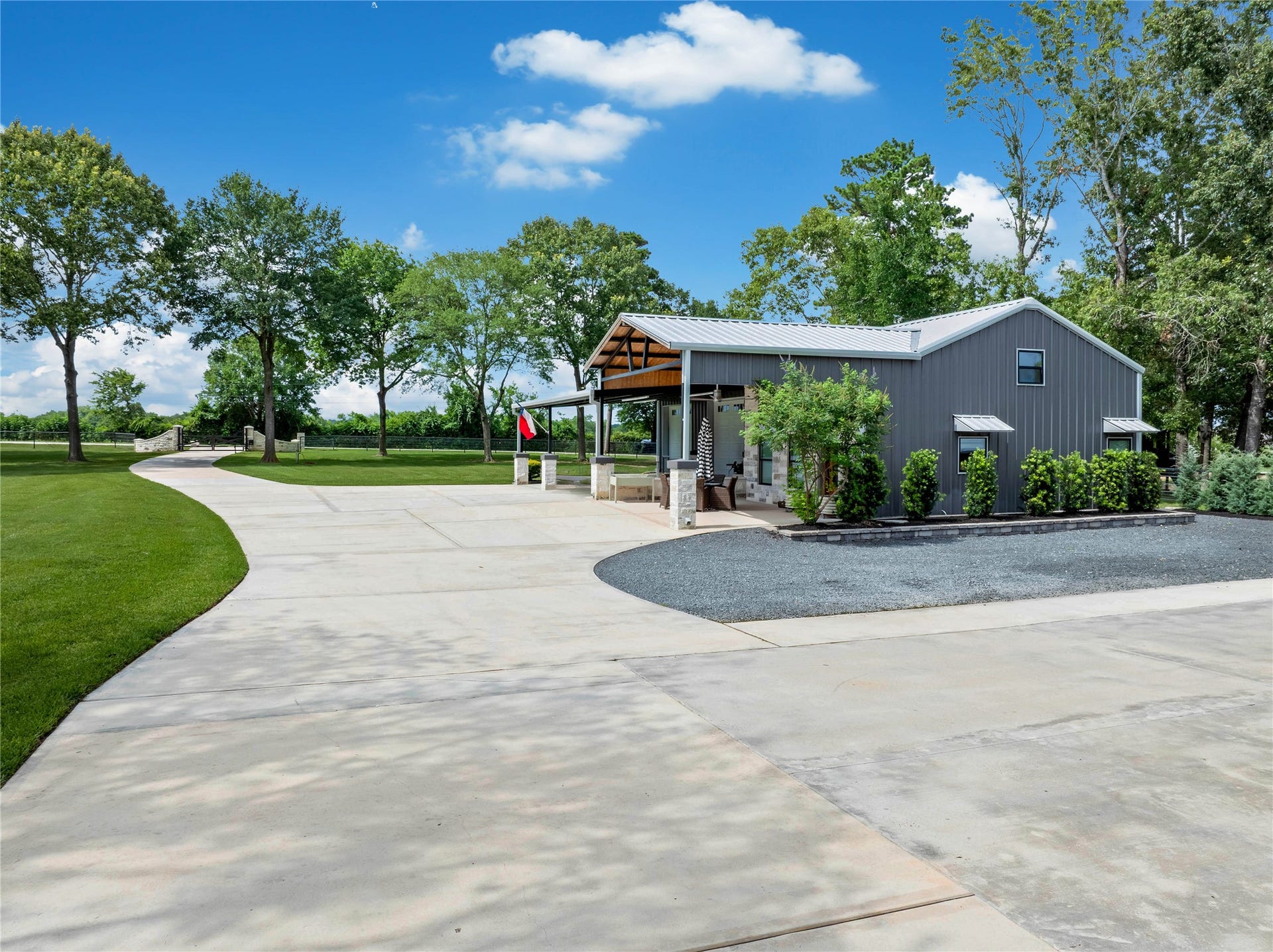 Expansive concrete driveway leads to the detached party barn and private garage apartment and carport.