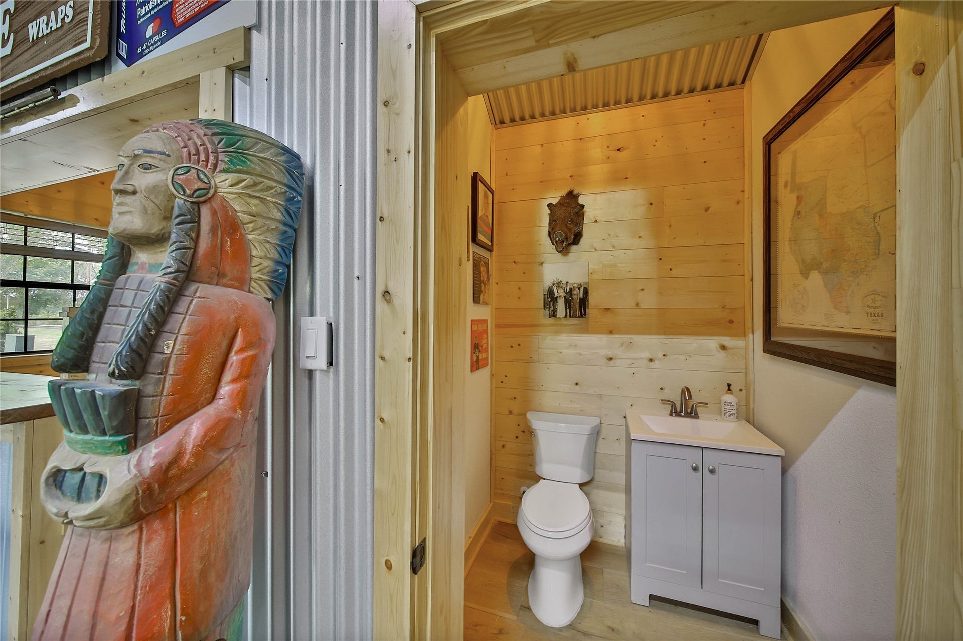 Convenient half bath in party barn features knotty pine accents.