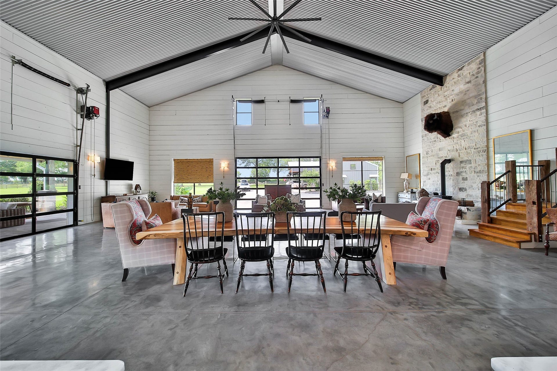 Grand dining area surrounded by soaring 20-foot ceilings, exposed steel beams, an open-concept design ideal for hosting large gatherings and unforgettable entertaining.
