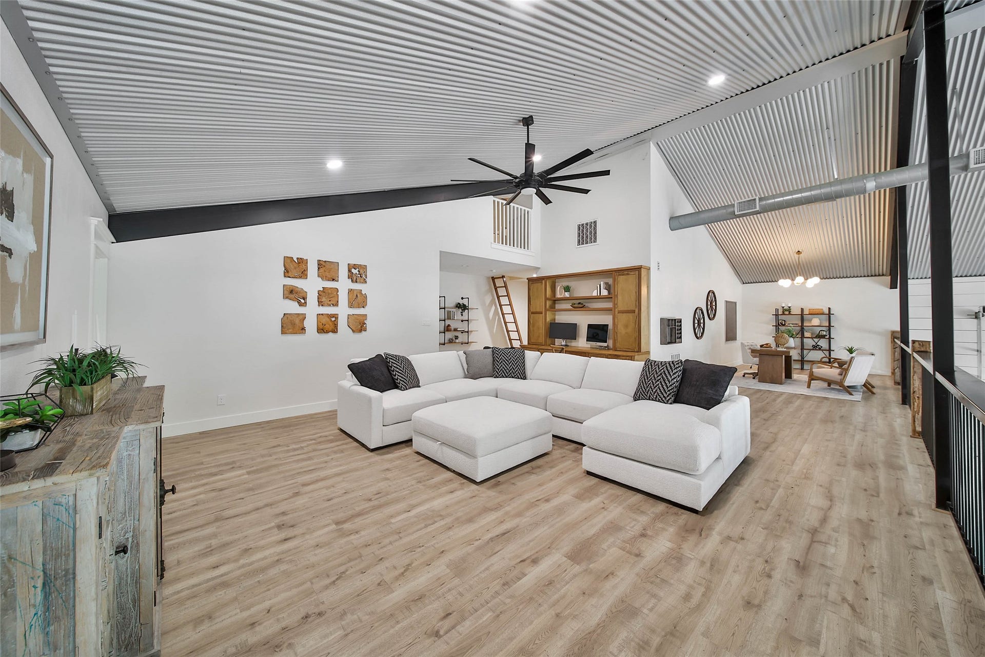 Expansive upstairs game room with soaring corrugated metal ceilings, built-in desk and shelving, plus an additional flex loft ideal for a playroom, reading nook, or extra storage. All upstairs rooms feature solid-core doors for added quality and privacy.