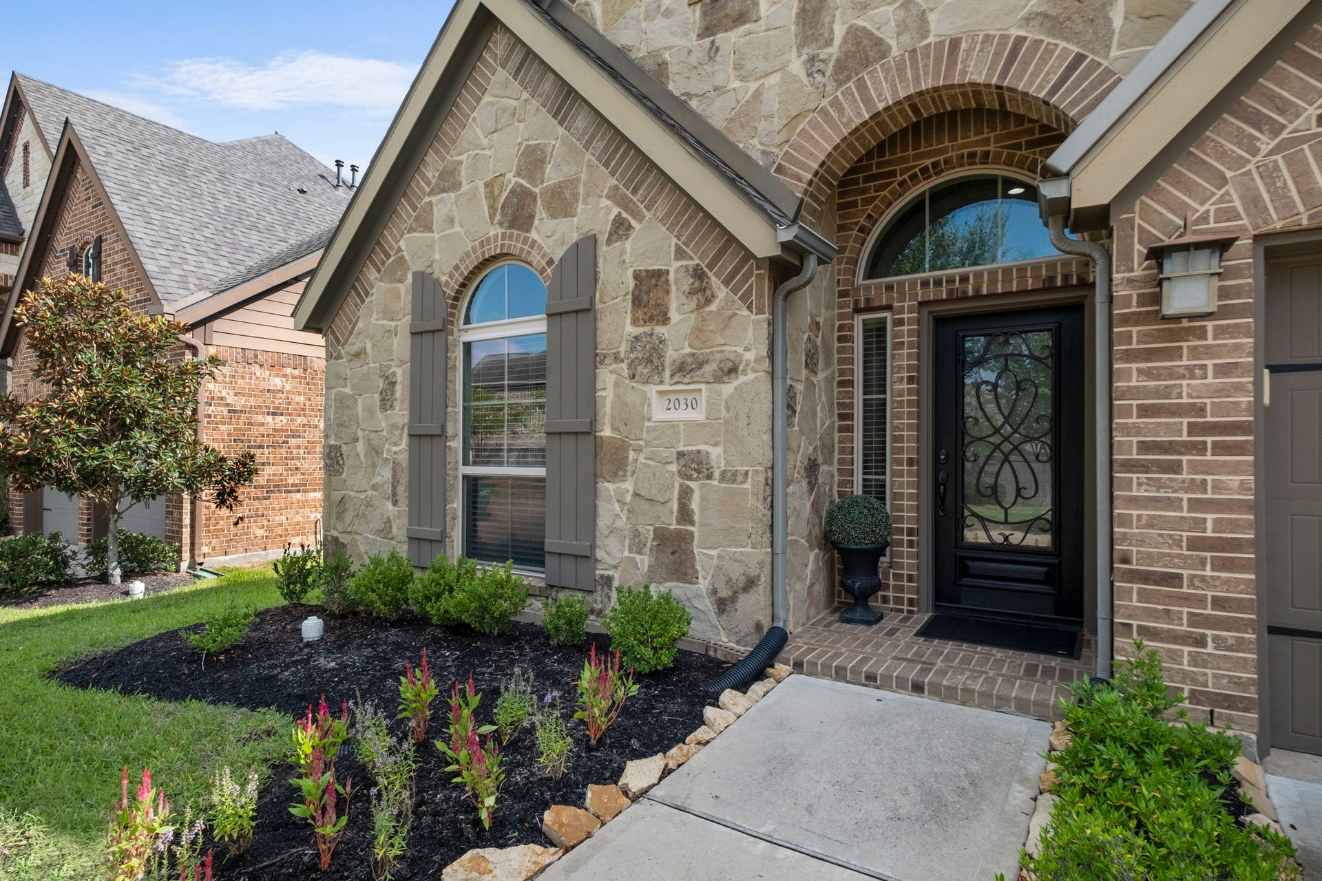 2030 Rainy Mist Drive, Missouri City, TX 77459 Welcoming covered entrance framed by attractive stonework and lush landscaping.