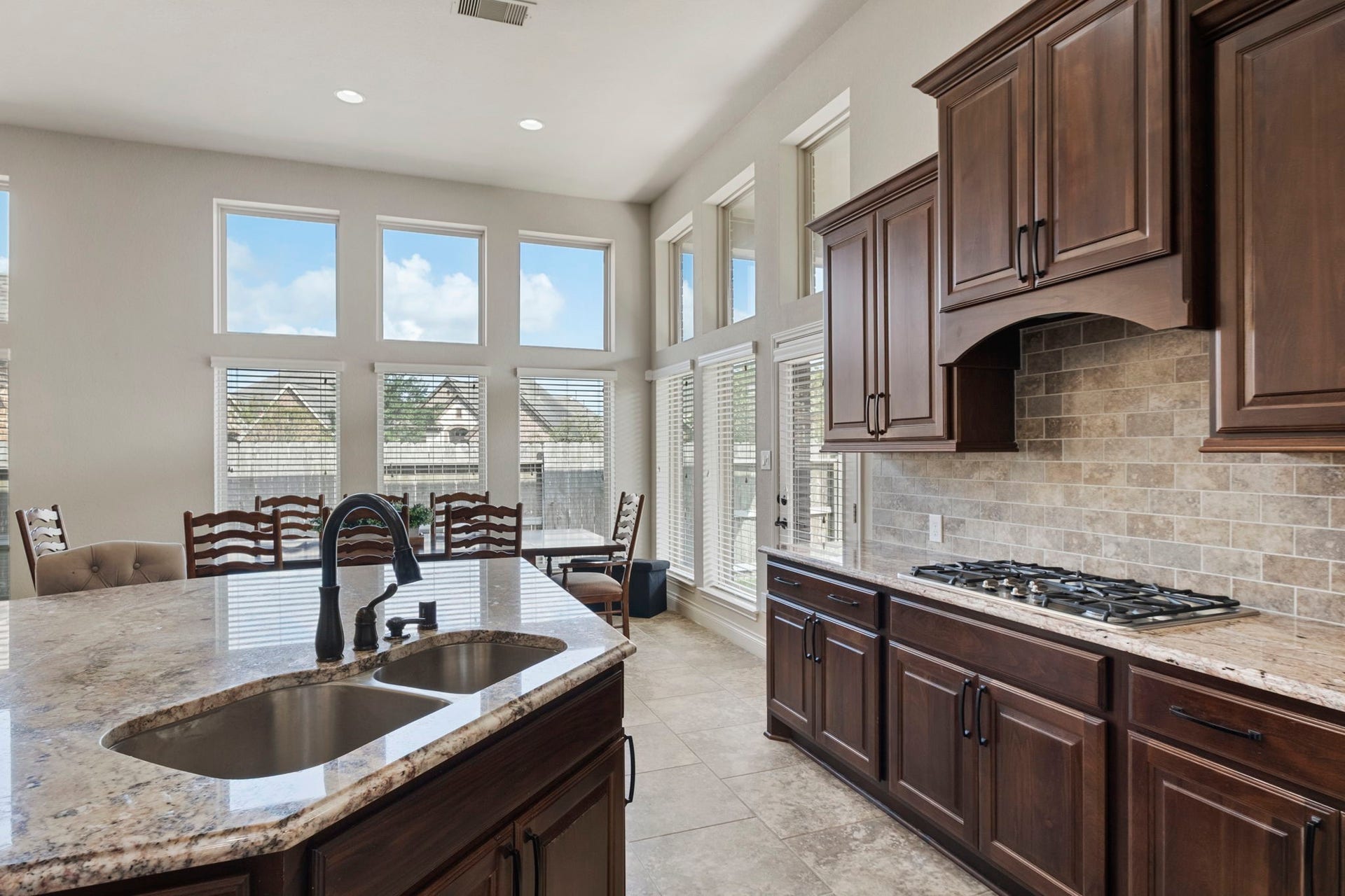 2030 Rainy Mist Drive, Missouri City, TX 77459 Well-appointed kitchen features a gas cooktop, tiled backsplash, and extensive upper and lower cabinetry.