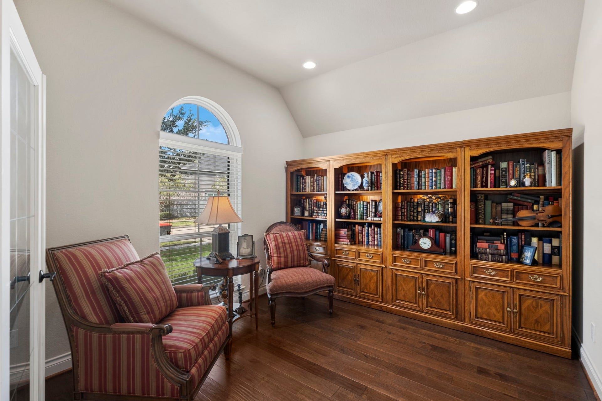 2030 Rainy Mist Drive, Missouri City, TX 77459 Private home office features rich built-in cabinetry, wood flooring, and a large arched window.