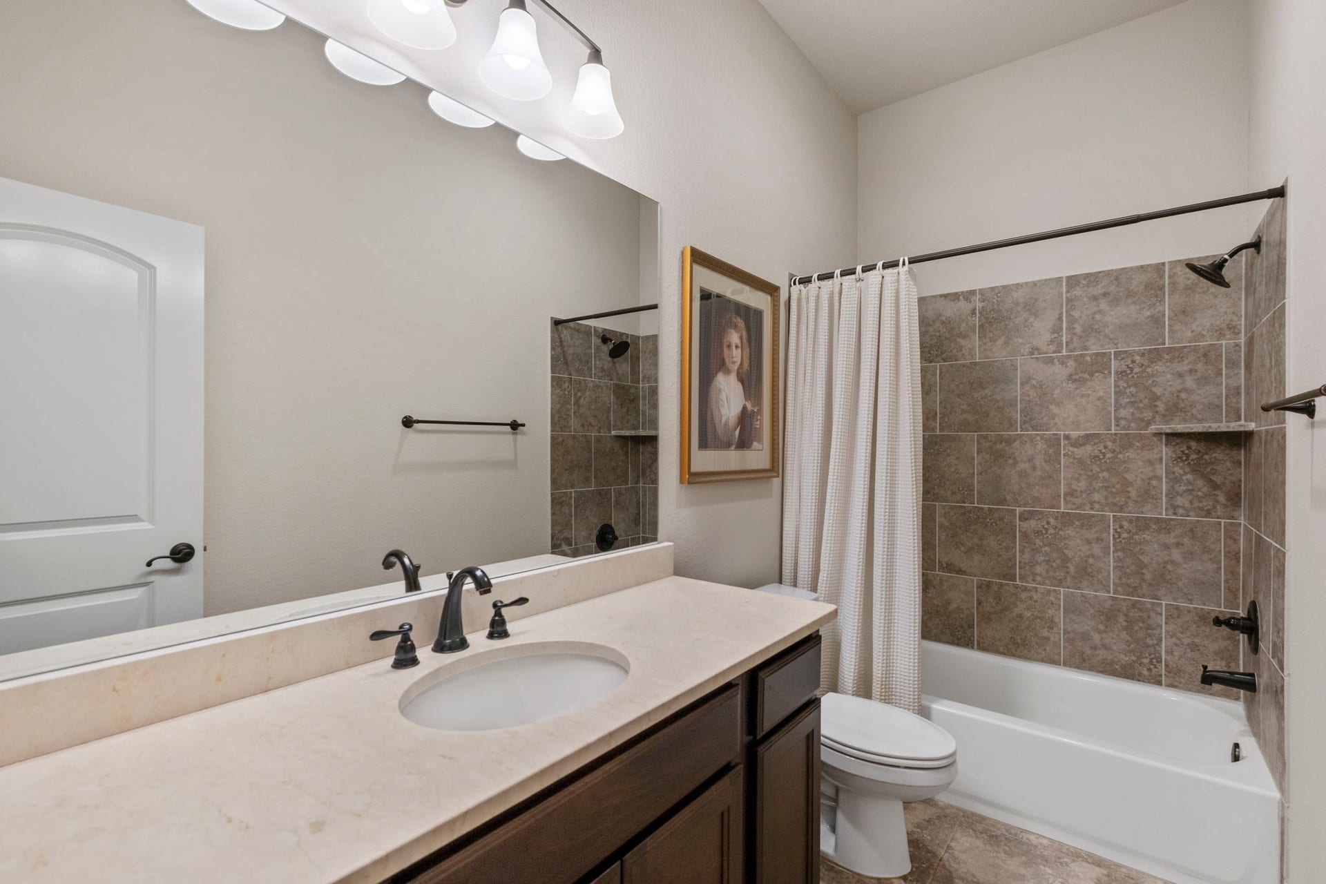 2030 Rainy Mist Drive, Missouri City, TX 77459 Secondary bath features a long vanity with ample counter space with Crema Marble, and a tiled tub/shower combination.