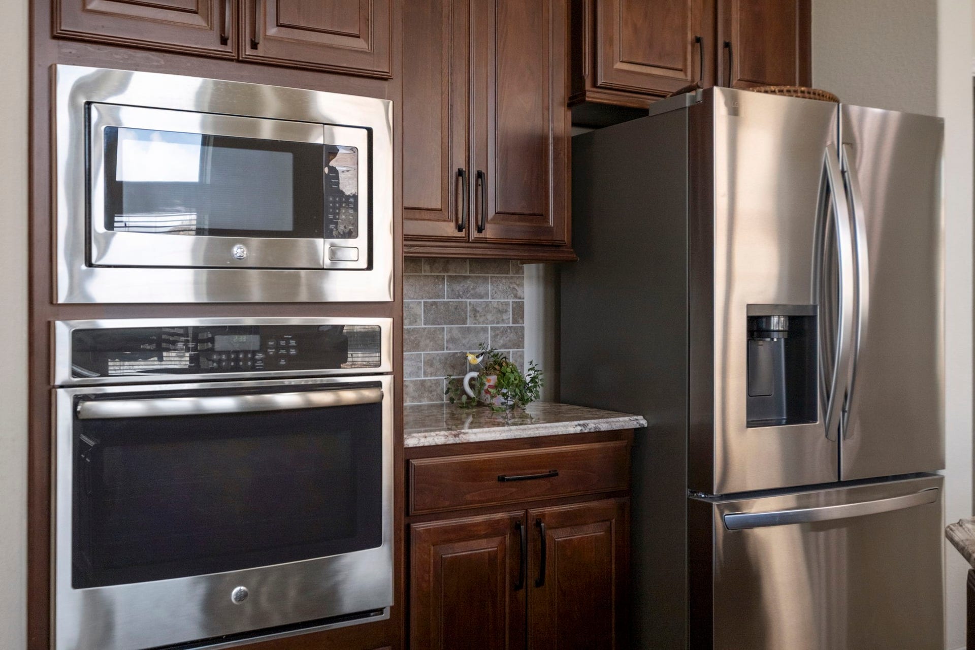 2030 Rainy Mist Drive, Missouri City, TX 77459 Stainless steel appliances, including an oven and a refrigerator, complement the warm cabinetry.