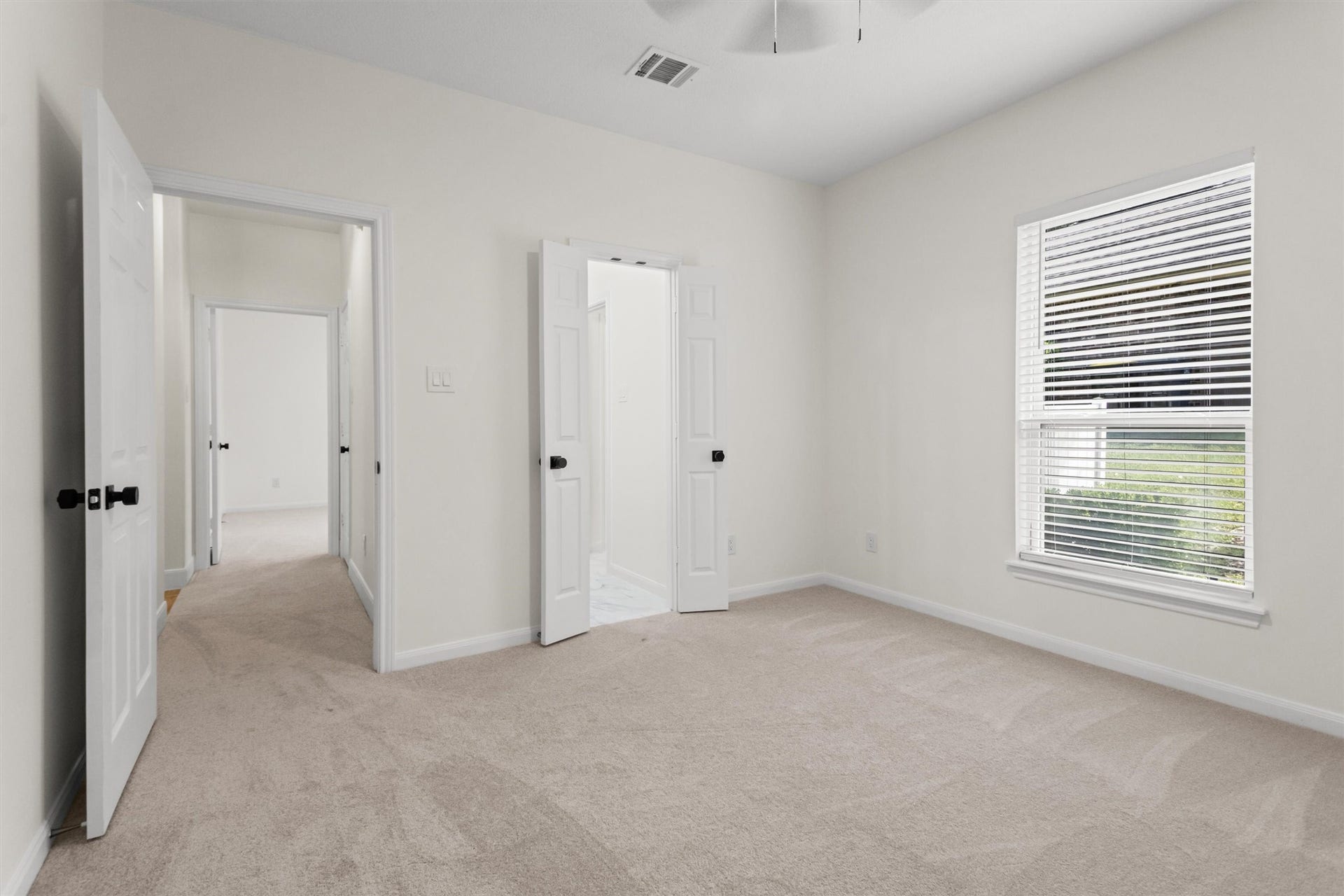 13 Royal Dalton Circle, Conroe, TX 77304 The second secondary bedroom is generously sized and features a convenient Hollywood bath. This view highlights the access points to both the private bathroom and the main hallway.