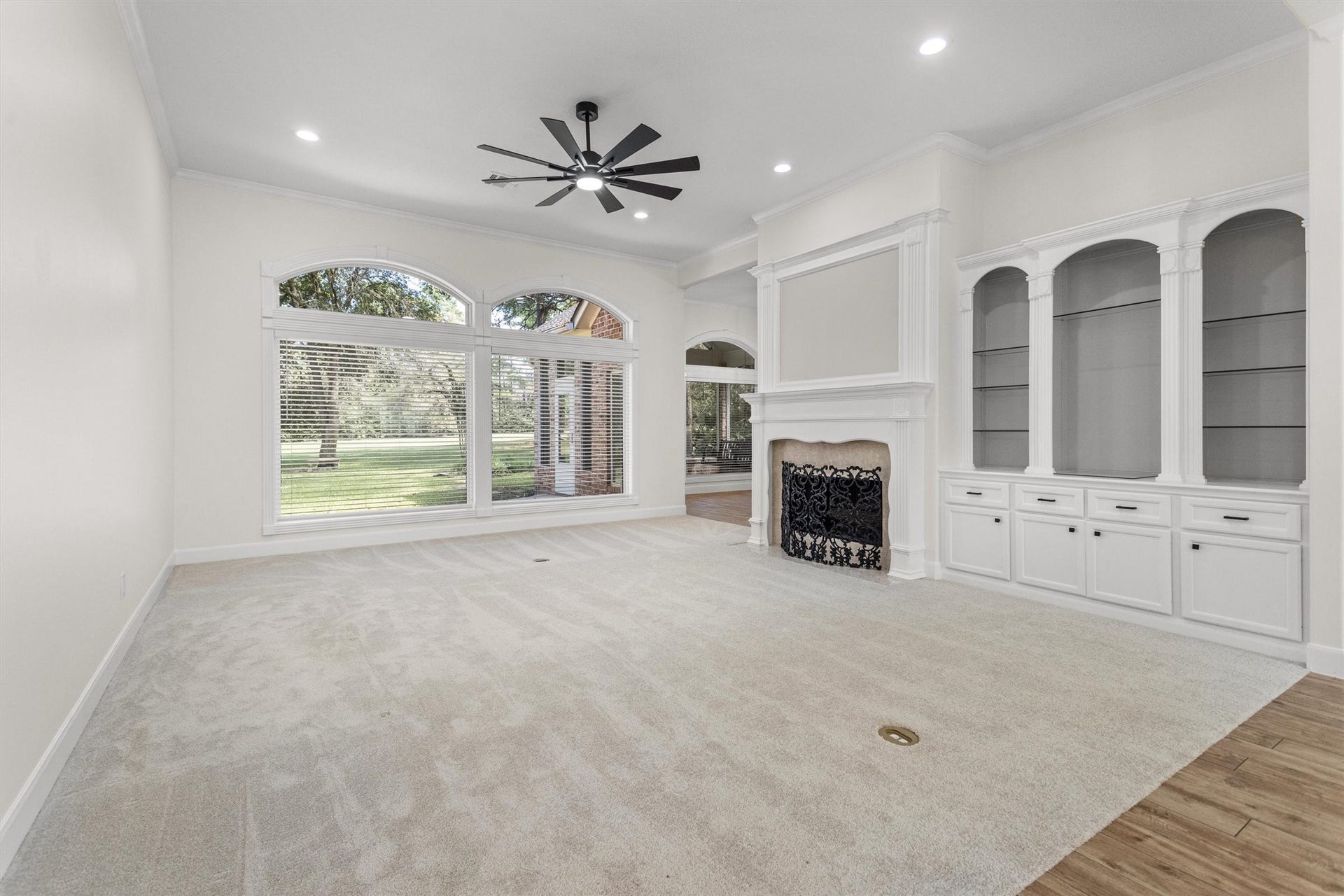 13 Royal Dalton Circle, Conroe, TX 77304 Spacious living room with fireplace, built-ins and backyard views. The seller has updated the home with paint throughout, flooring and fixtures.