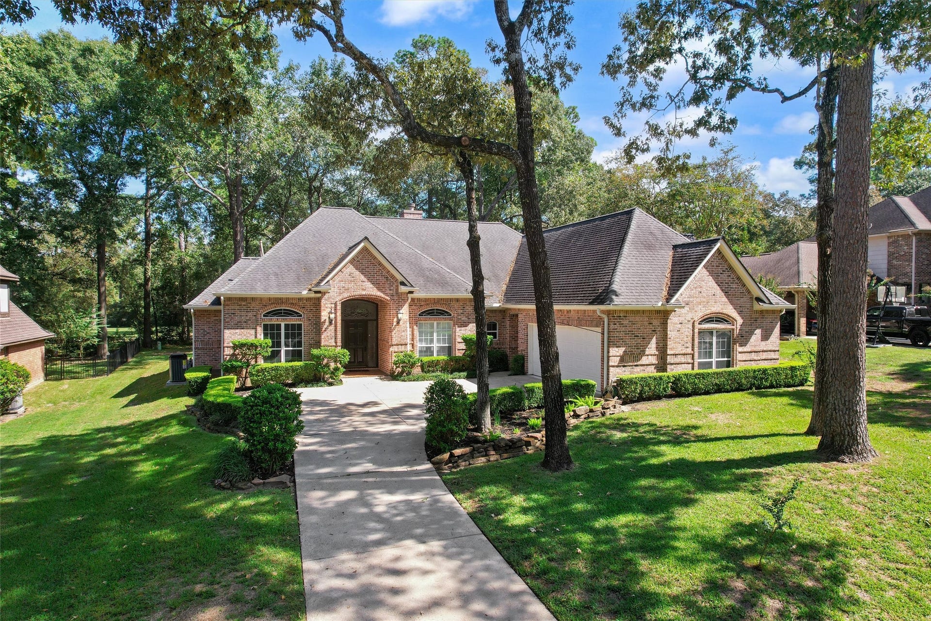 13 Royal Dalton Circle, Conroe, TX 77304 A tree-lined approach and curved drive with established landscaping creates inviting curb appeal.