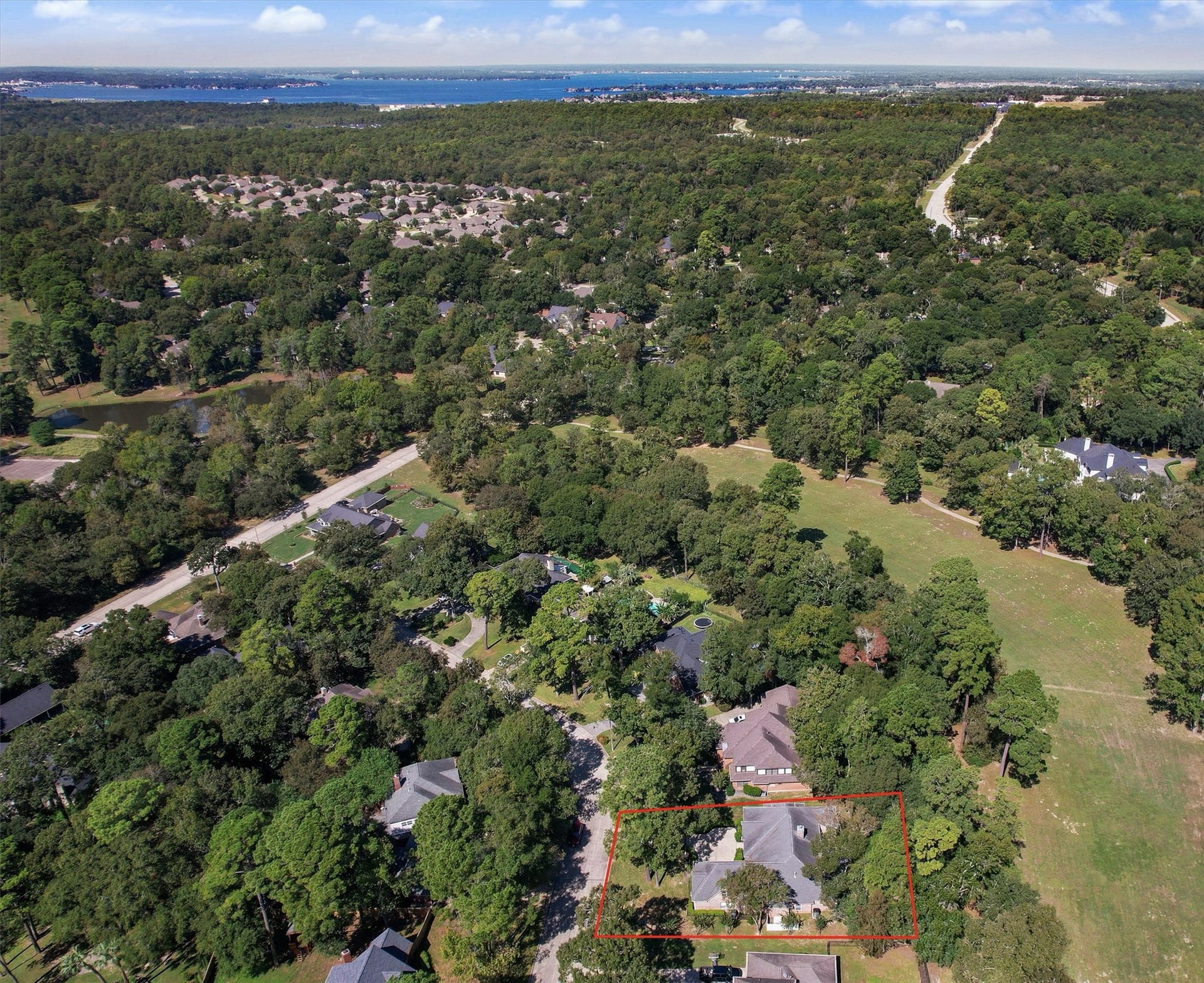 13 Royal Dalton Circle, Conroe, TX 77304 Aerial view shows the home and its proximity to the adjoining greenspace (former Wedgewood Golf Course now owned by City of Conroe) and to Lake Conroe.