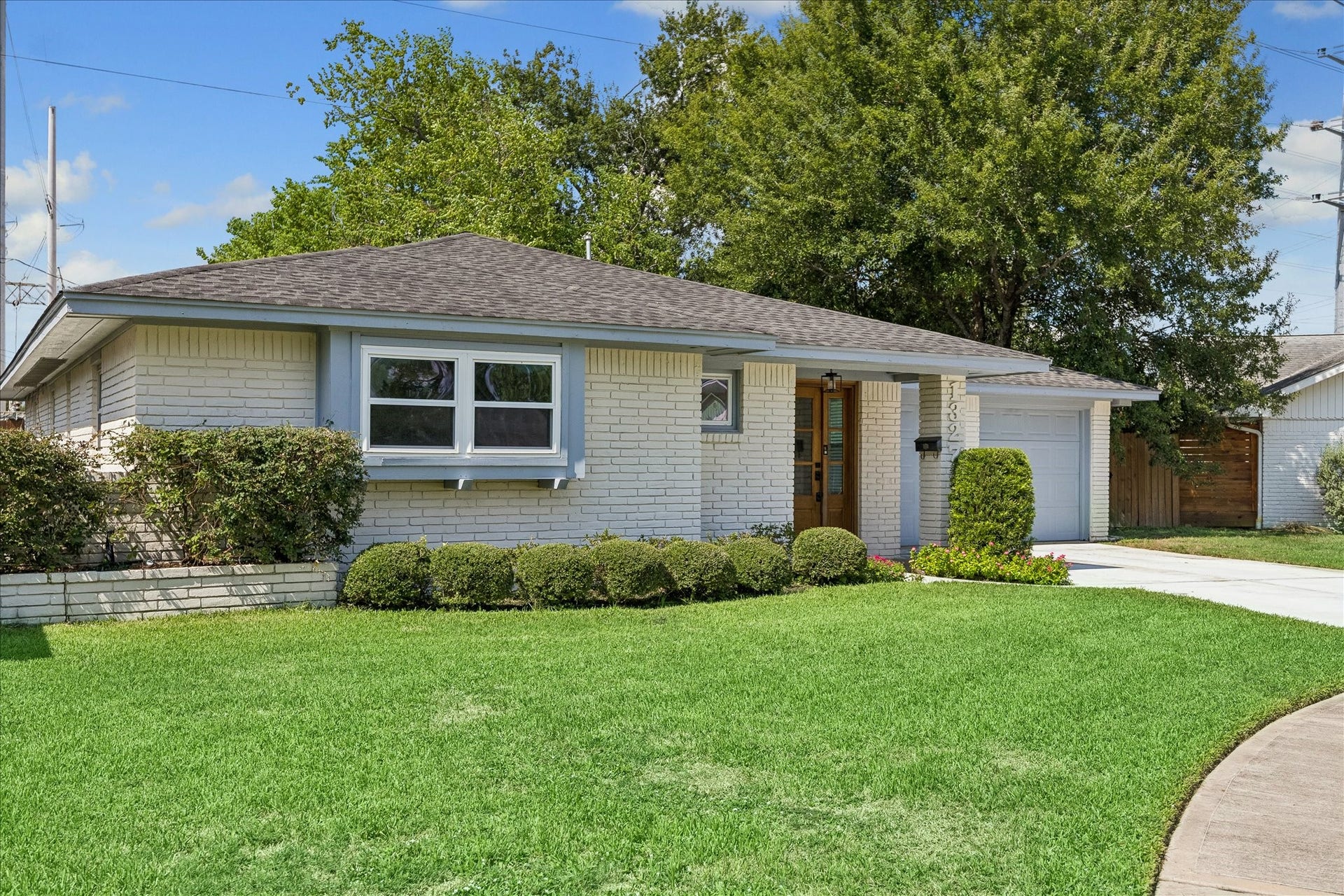 Charming one-story home with an inviting front entry, mature landscaping and a beautiful lawn.