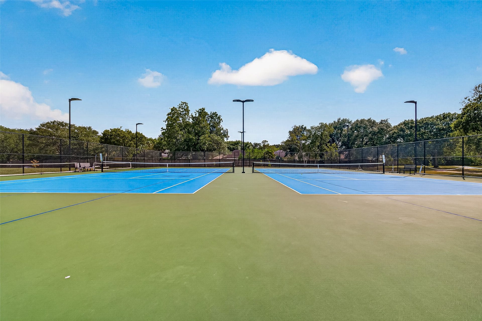 Enjoy an active lifestyle with access to well-maintained tennis courts set amidst lush greenery and open skies.