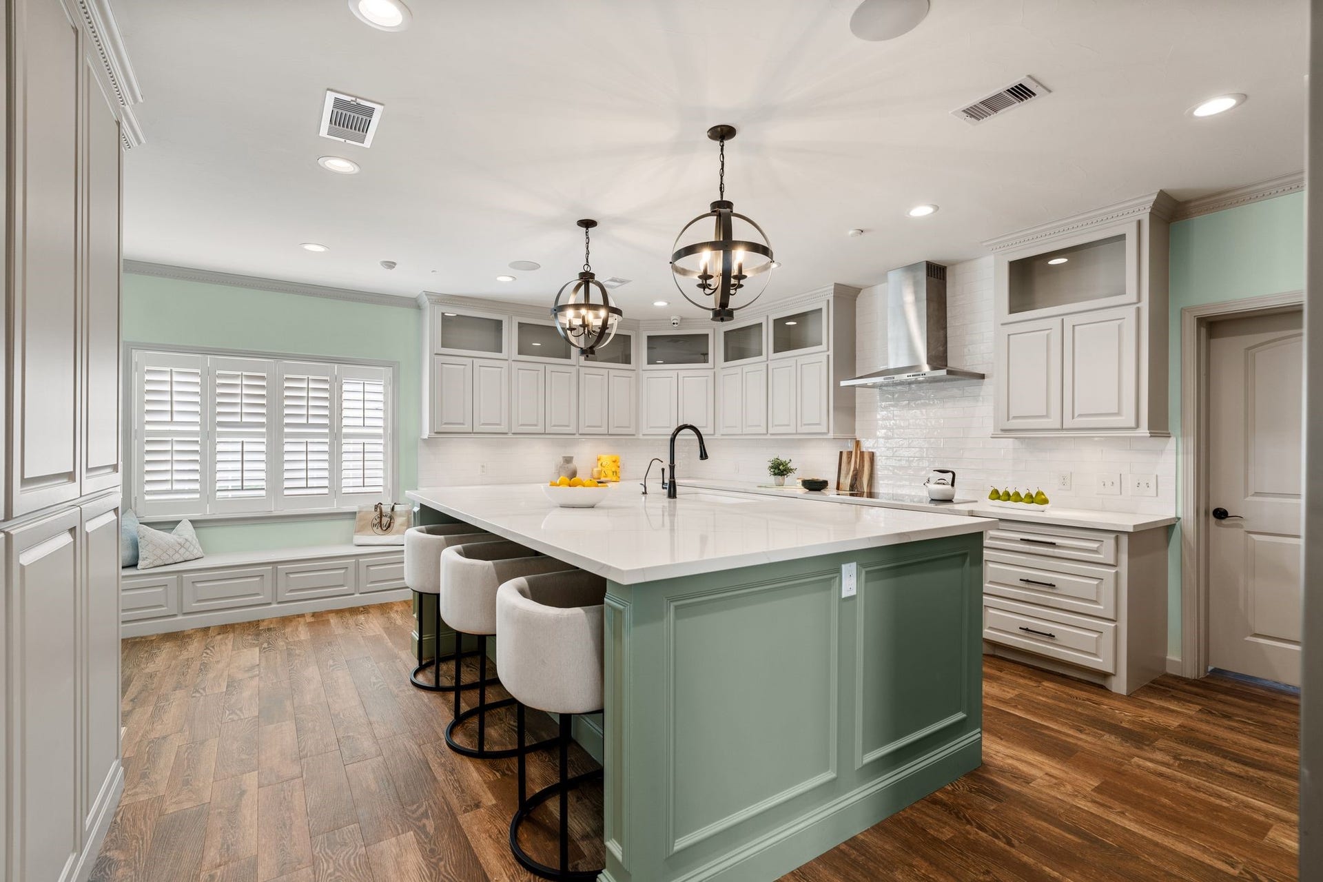 8619 La Fonte Street, Houston, TX 77024 Fully gutted & remodeled in 2012, the kitchen centers around an oversized island w. quartz countertops, breakfast bar seating & contrasting cabinetry. 2 decorative pendant lights hang above island, while recessed lighting, ceiling speakers & dentil crown molding add detail throughout. A large window with plantation shutters sits above built-in bench seating with additional storage below. The door to left of bench leads to 2 car garage while door on right leads to mudroom/utility room & add'l 1 car garage.