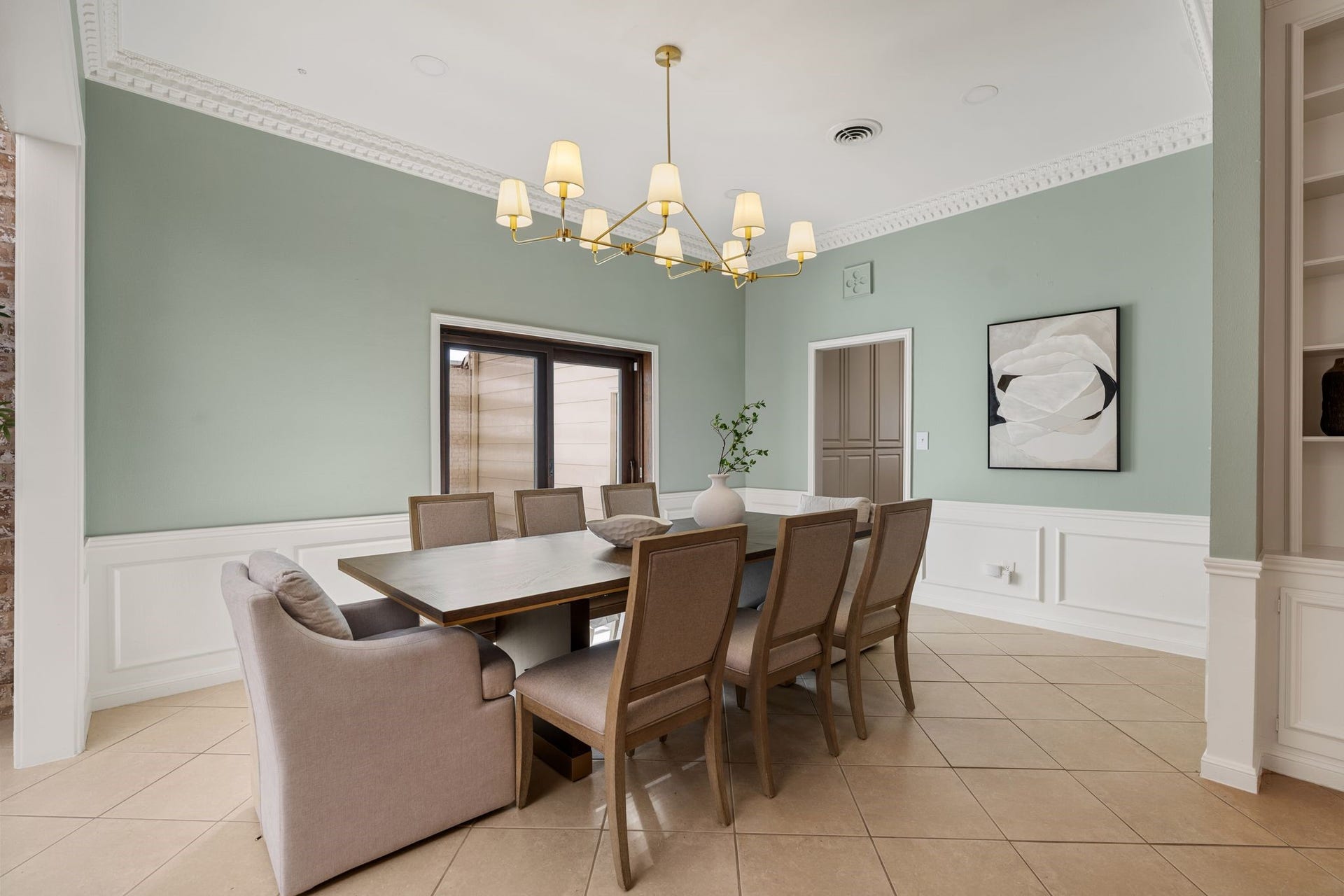 8619 La Fonte Street, Houston, TX 77024 The formal dining room is positioned just off the kitchen and features neutral tile flooring, recessed lighting, decorative dentil molding and wainscoting with chair rail detail. A gold chandelier adds a polished finishing touch, while sliding glass doors open directly to the courtyard and bring in additional natural light.
