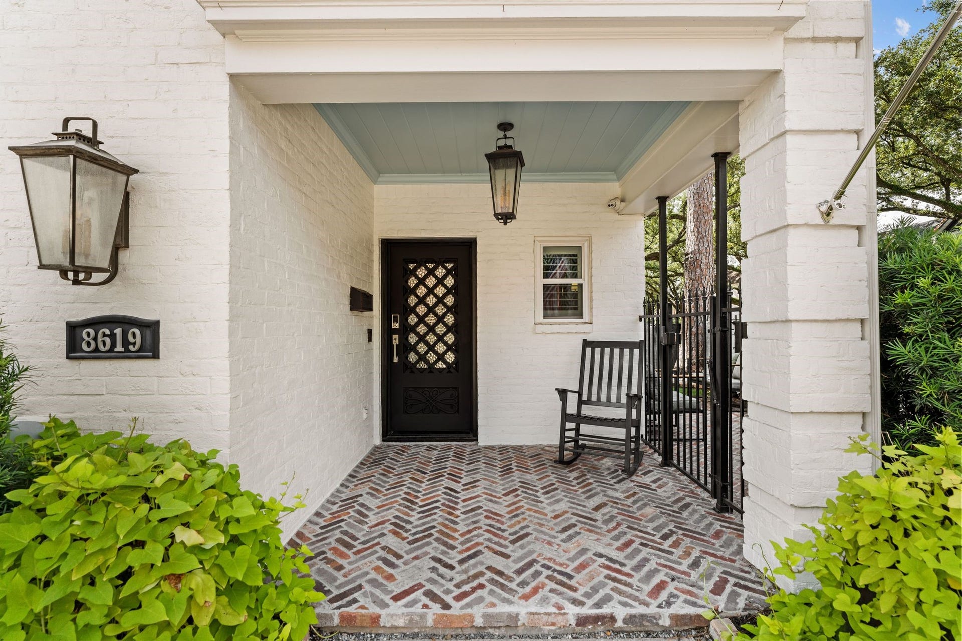 8619 La Fonte Street, Houston, TX 77024 The covered front entry is finished with herringbone brick flooring, lantern-style lighting and a striking iron front door with keyless entry. An iron gate to the right provides direct access to the private turfed side yard, adding both convenience and function to the home's exterior.