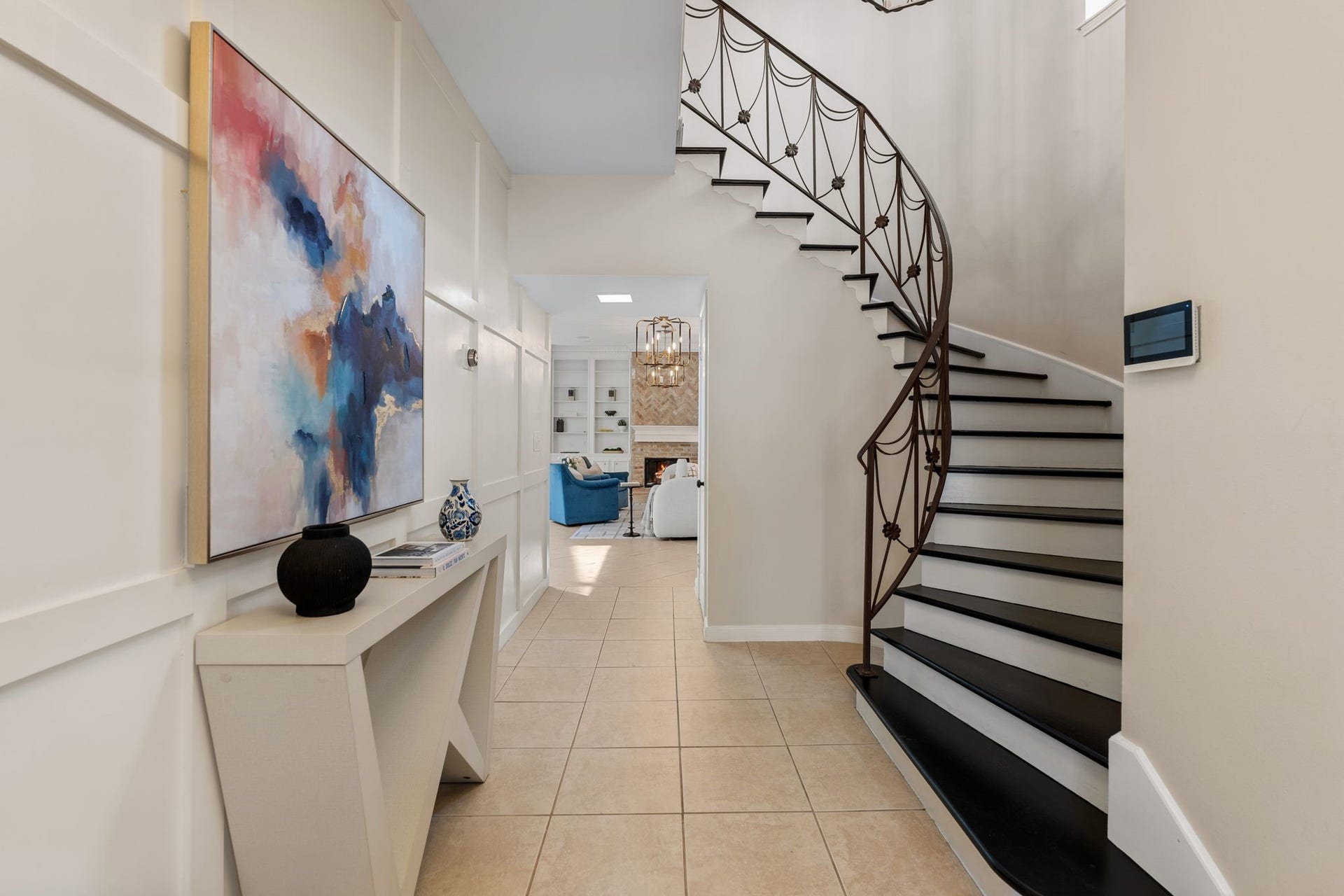 8619 La Fonte Street, Houston, TX 77024 The entry opens with a paneled accent wall that provides plenty of room to display artwork or an entry console, while the dramatic curved staircase immediately draws the eye with its intricate iron detailing. The staircase continues to the second floor beneath a chandelier and window, with an arched wall niche and under-stair closet adding both character and additional storage.