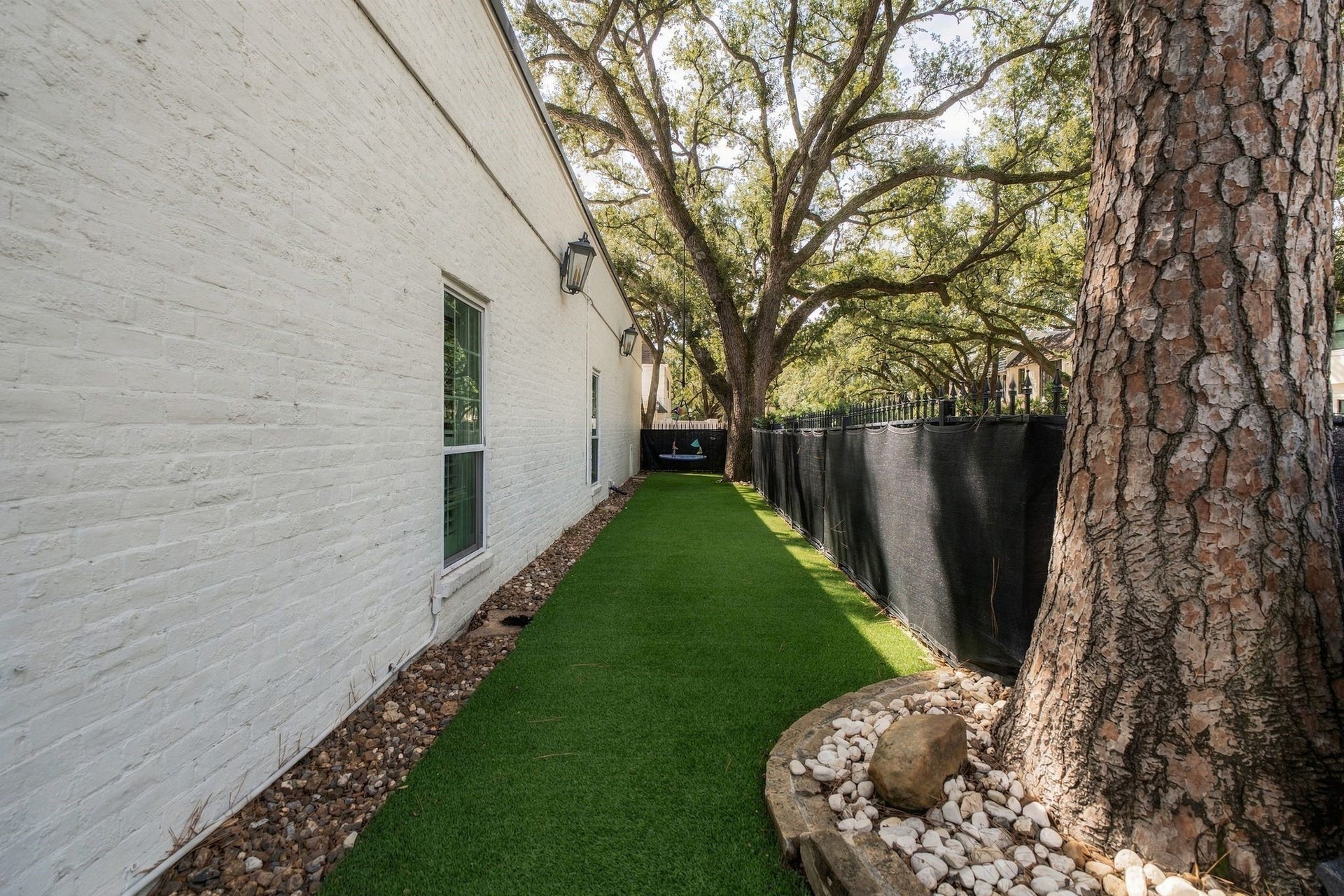 8619 La Fonte Street, Houston, TX 77024 A longer view showcases the low-maintenance turf extending along the side of the home beneath a canopy of mature trees. The generous length of the yard offers plenty of room for play, pets or additional outdoor use.