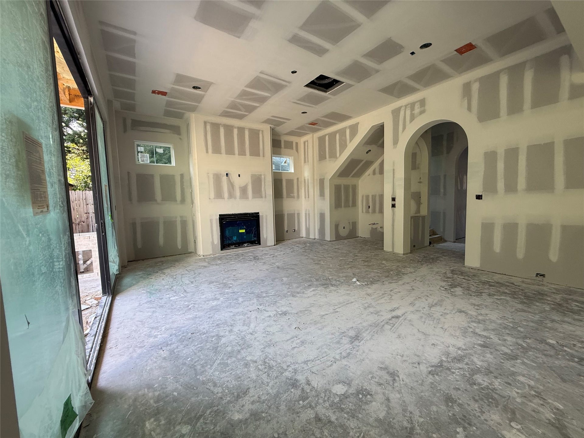 1021 Nadine Street, Houston, TX 77009 Open floorplan living area with gas fireplace, built in white oak cabinetry to the left and right, and wet bar under the staircase