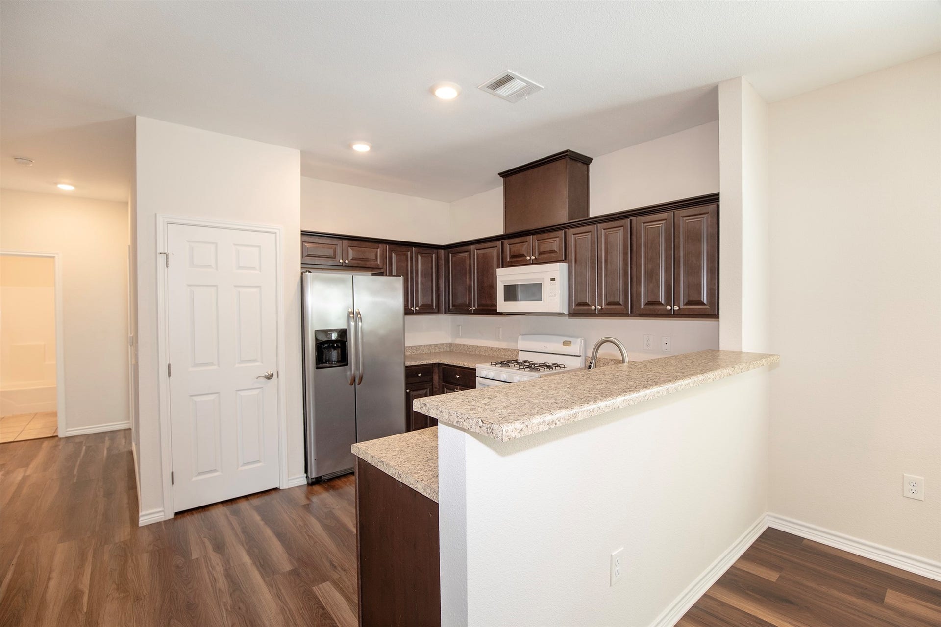 The raised breakfast bar sits above the kitchen counter, providing a convenient spot for casual dining, morning coffee, or additional seating.