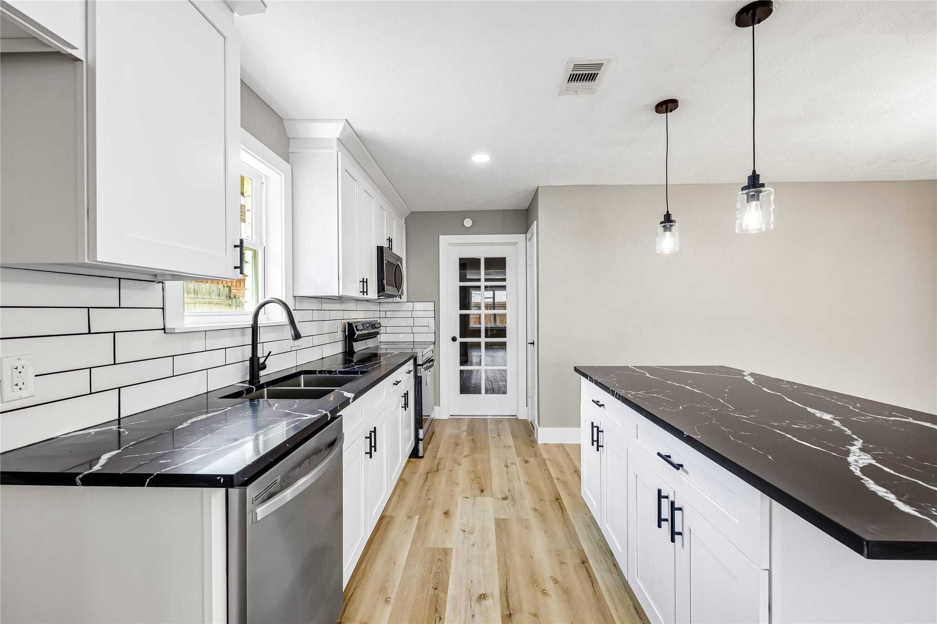 1803 Thornbrook Drive, Missouri City, TX 77489 The large island provides generous prep and serving space, while the clean finishes and pendant lighting give the kitchen a polished, contemporary feel.