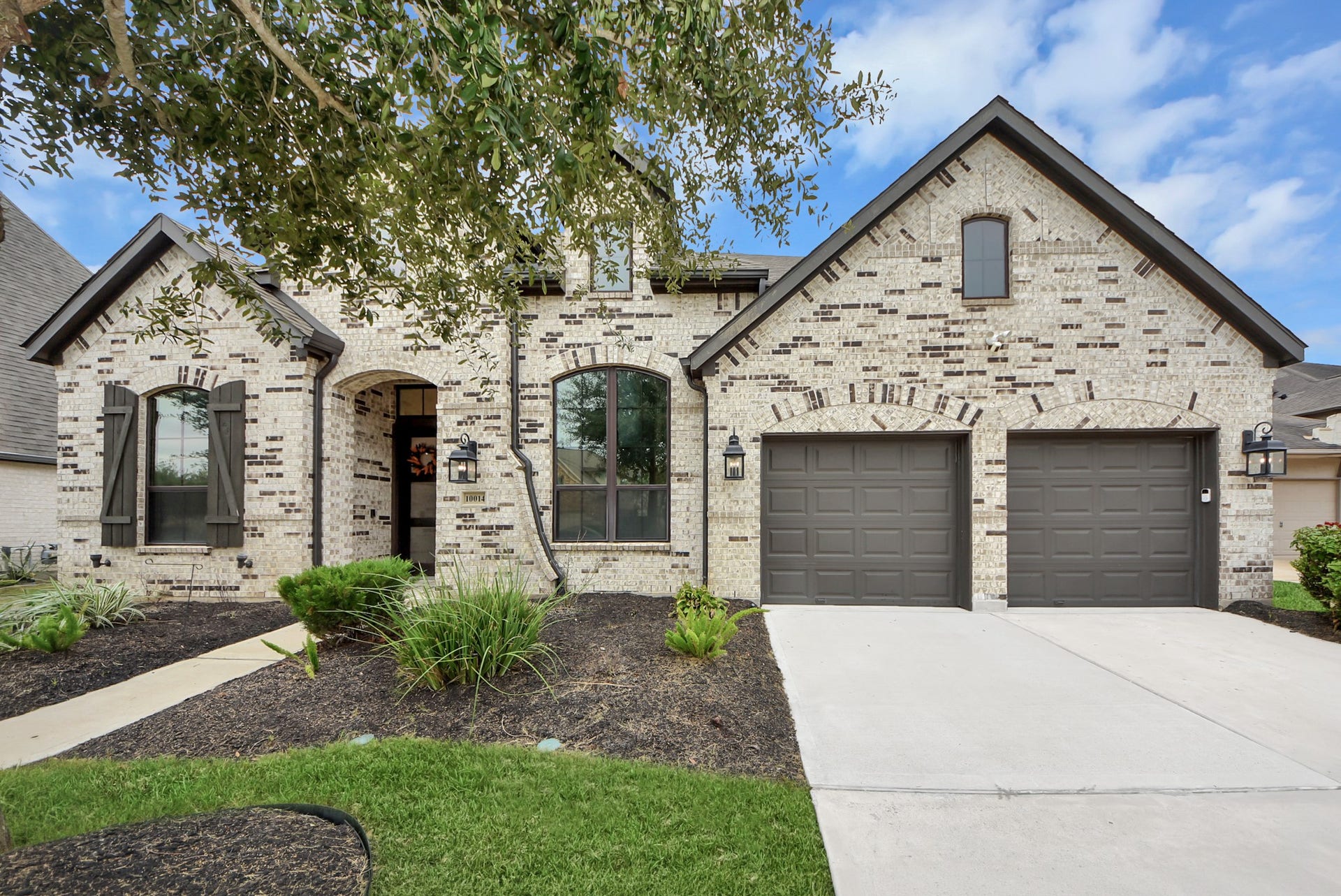 10014 Galileo Lane, Iowa Colony, TX 77583 Welcoming front elevation featuring attractive landscaping and a spacious driveway.