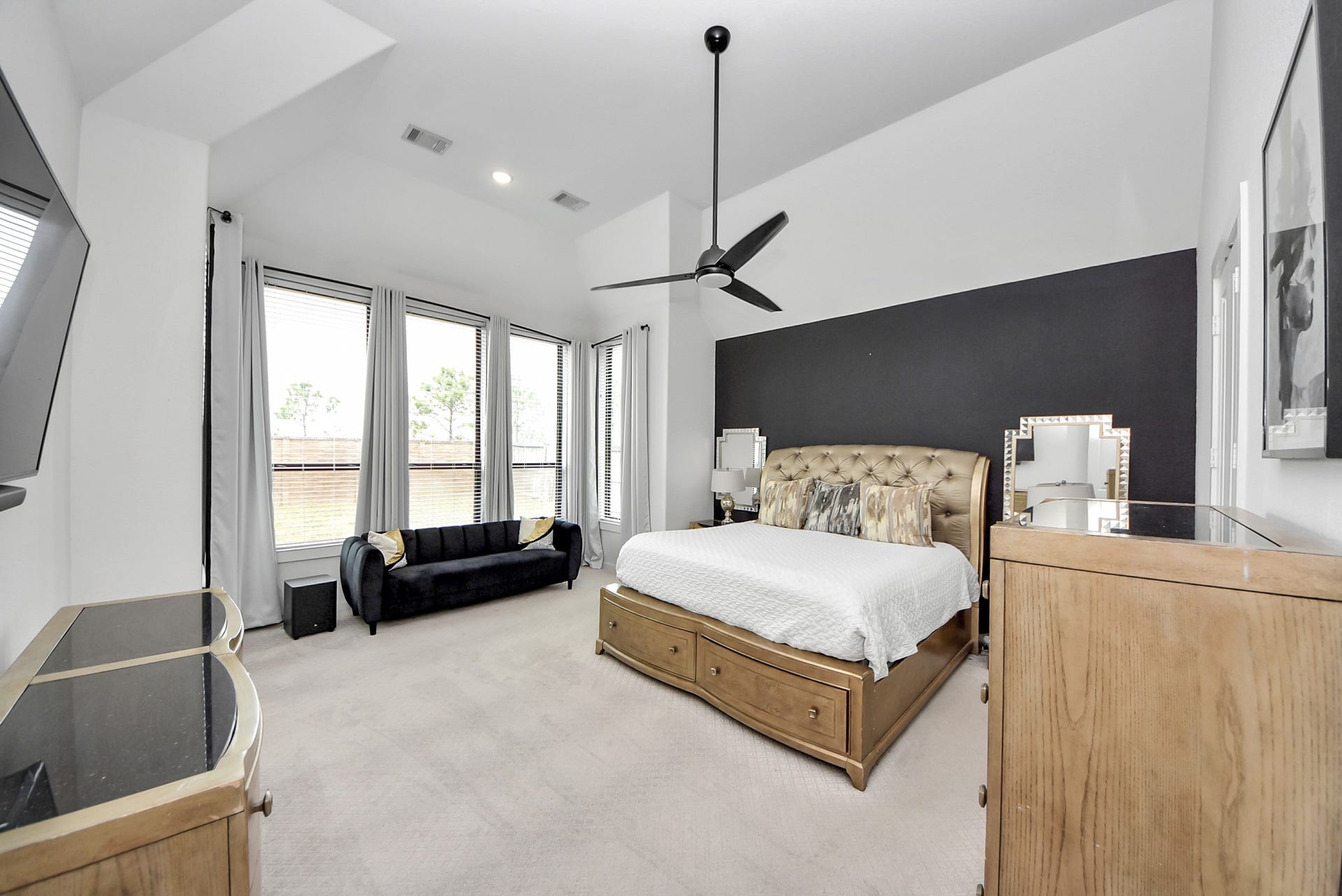 10014 Galileo Lane, Iowa Colony, TX 77583 Spacious primary bedroom featuring a stylish accent wall and large windows.