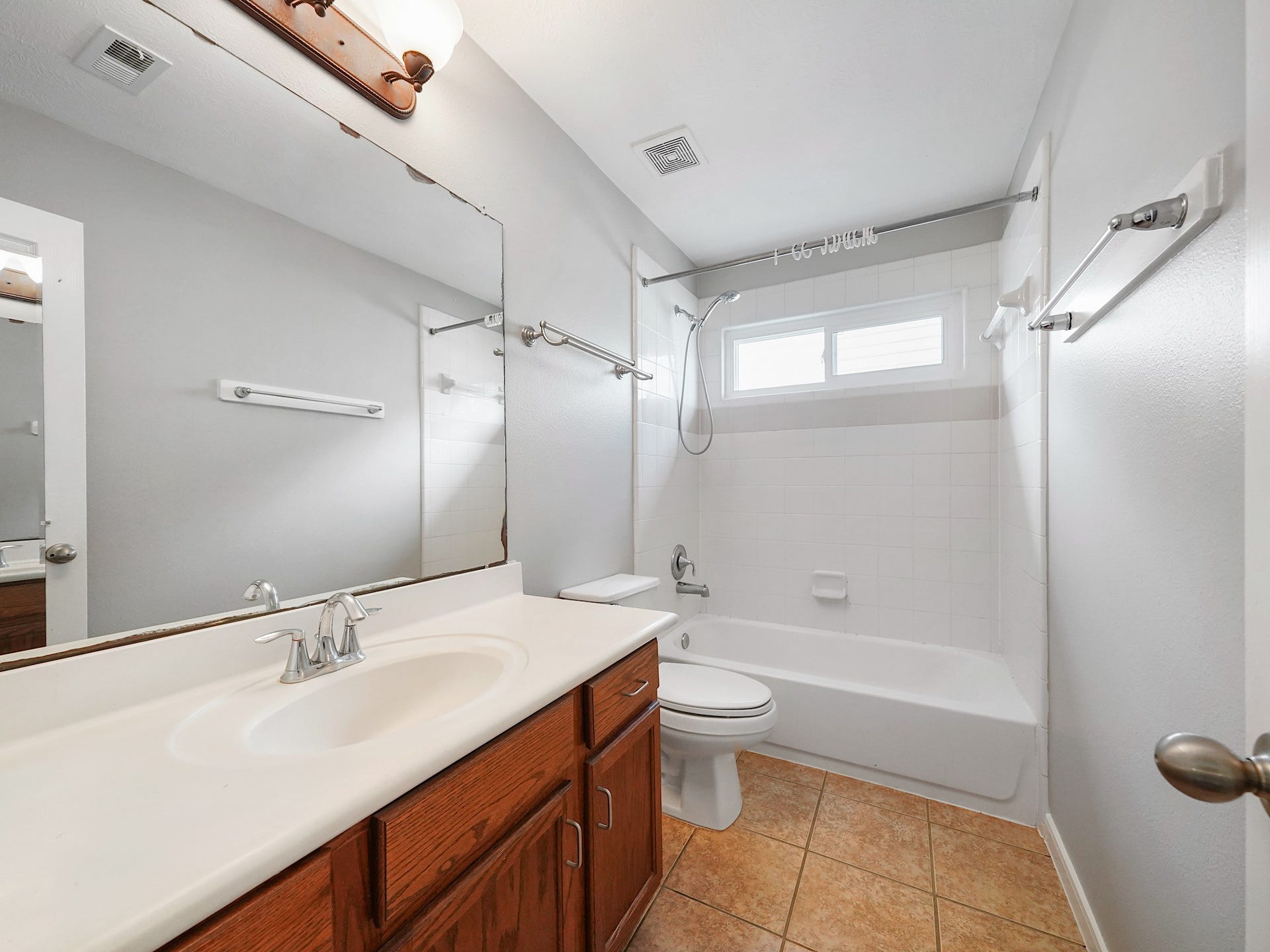 The full secondary bath near the game and media rooms offers a long vanity and tub/shower combination for comfort and convenience.