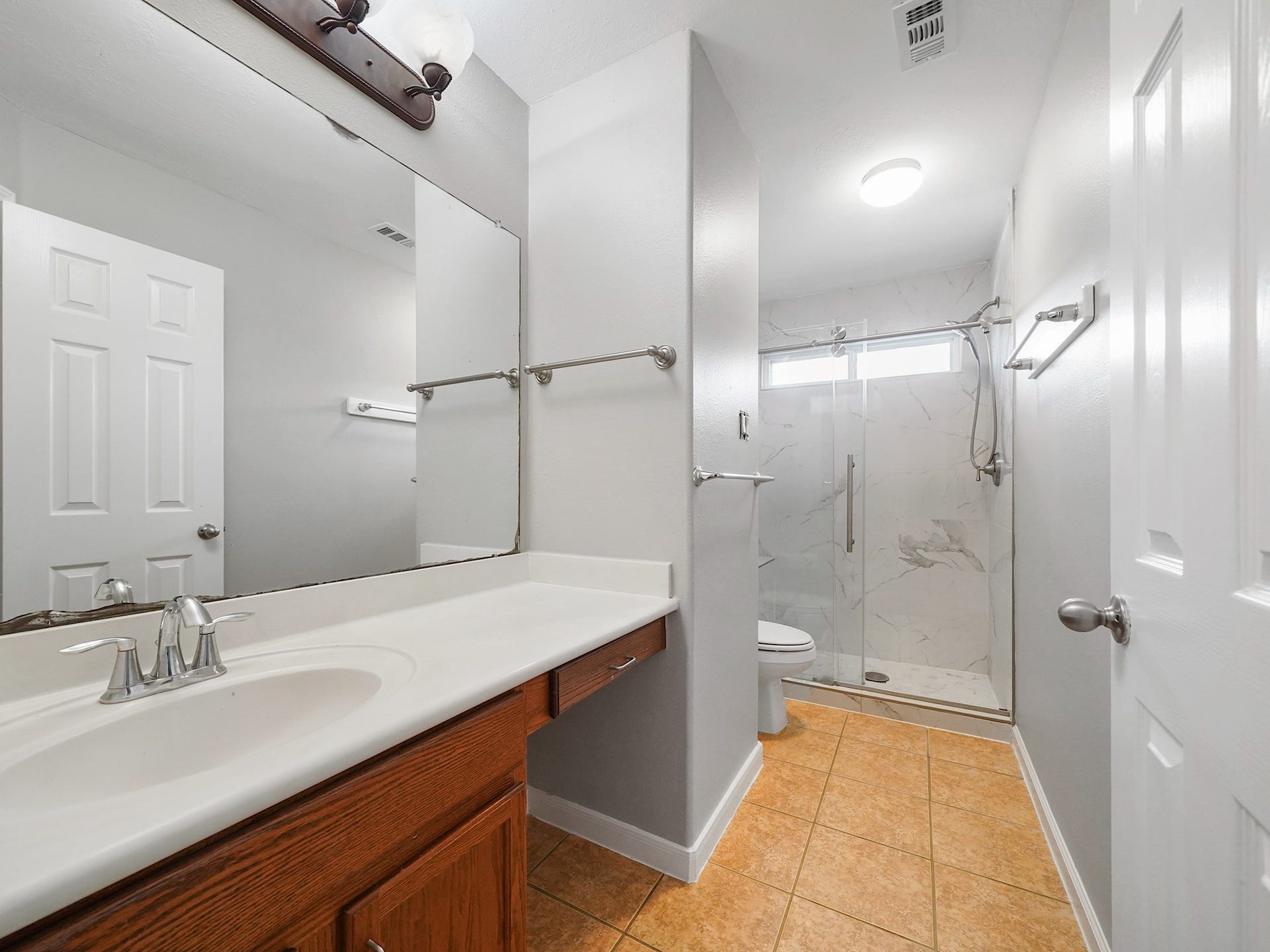 The upstairs secondary bath offers a large vanity and a bright, functional design.