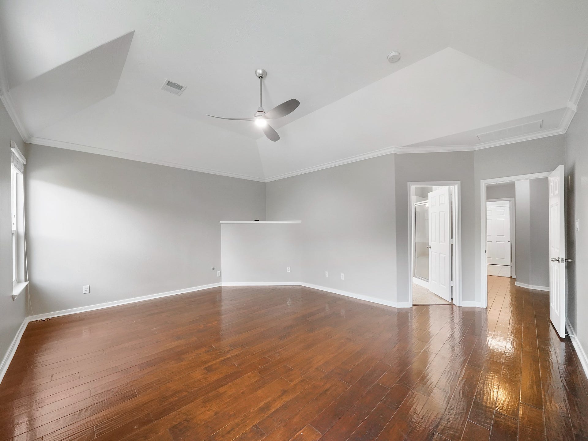 A wide secondary view shows the primary suites generous footprint, rich flooring, and flexible furnishing options.
