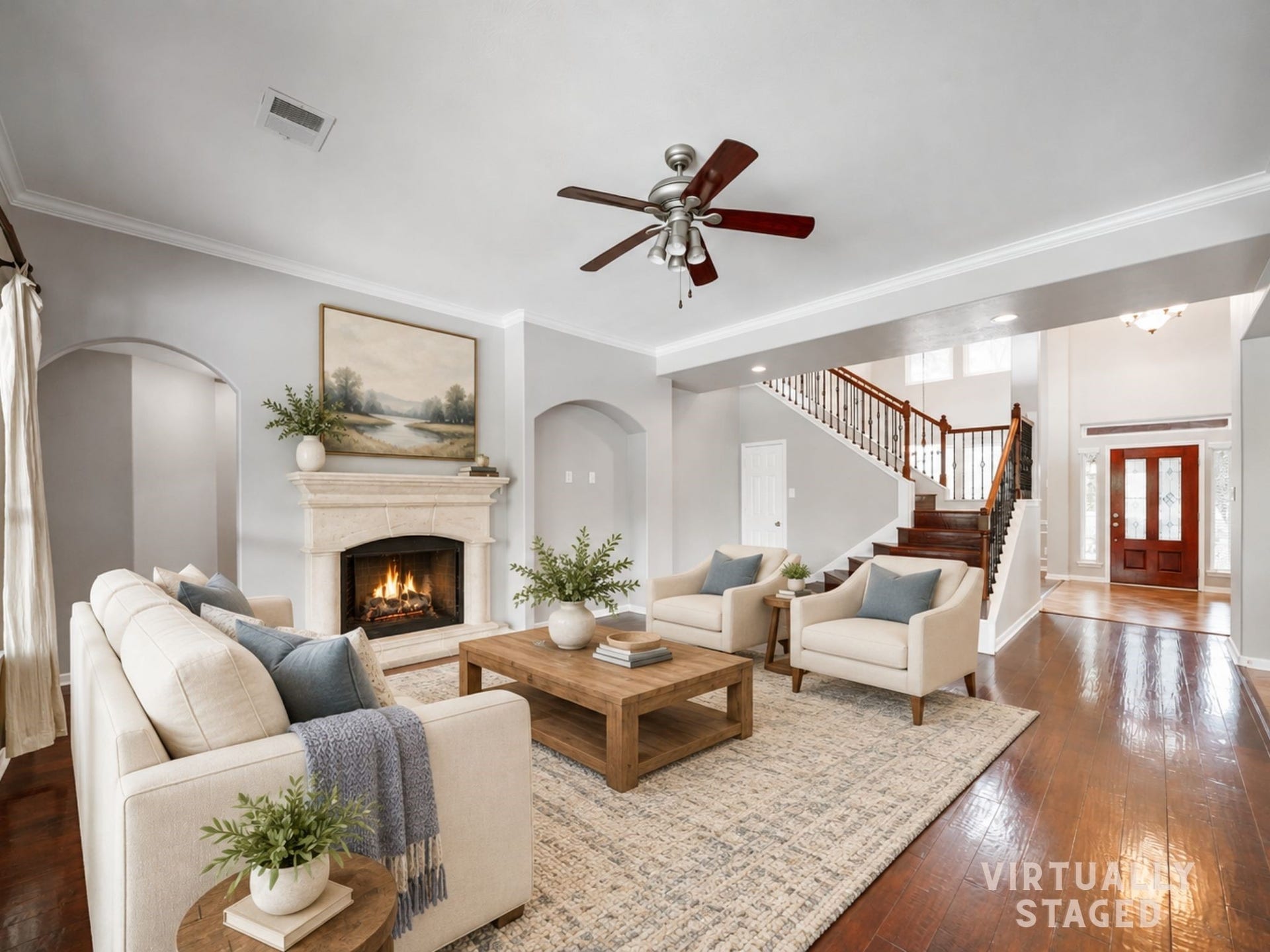 Virtually staged: The living room creates an inviting place to gather around the fireplace, with arched openings and open sightlines to the foyer and staircase.