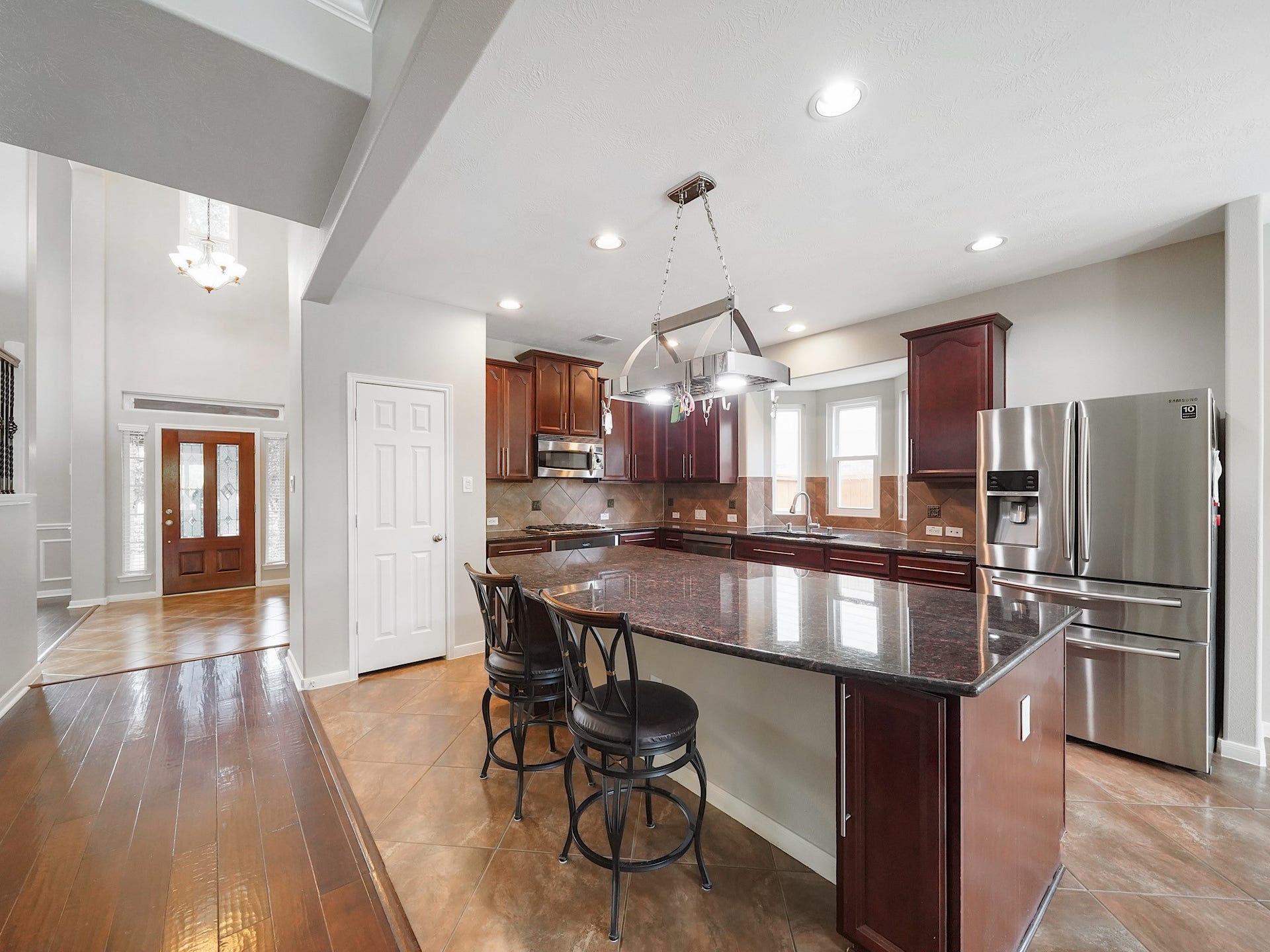The kitchen is designed for both daily life and entertaining, with rich cabinetry, generous counter space, and a spacious central island.