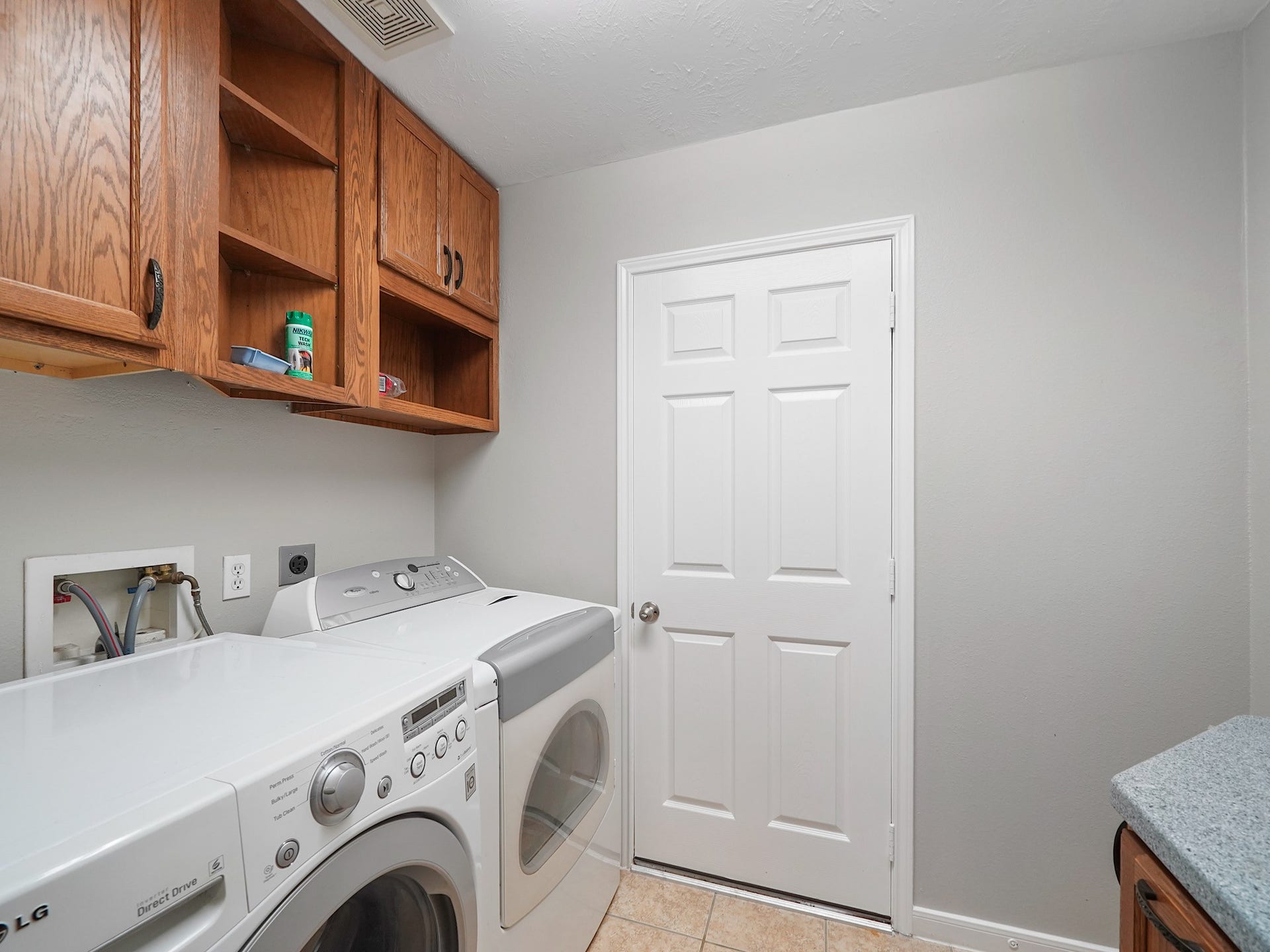The laundry room combines upper cabinetry, counter space, and room for appliances to make daily tasks feel effortless.