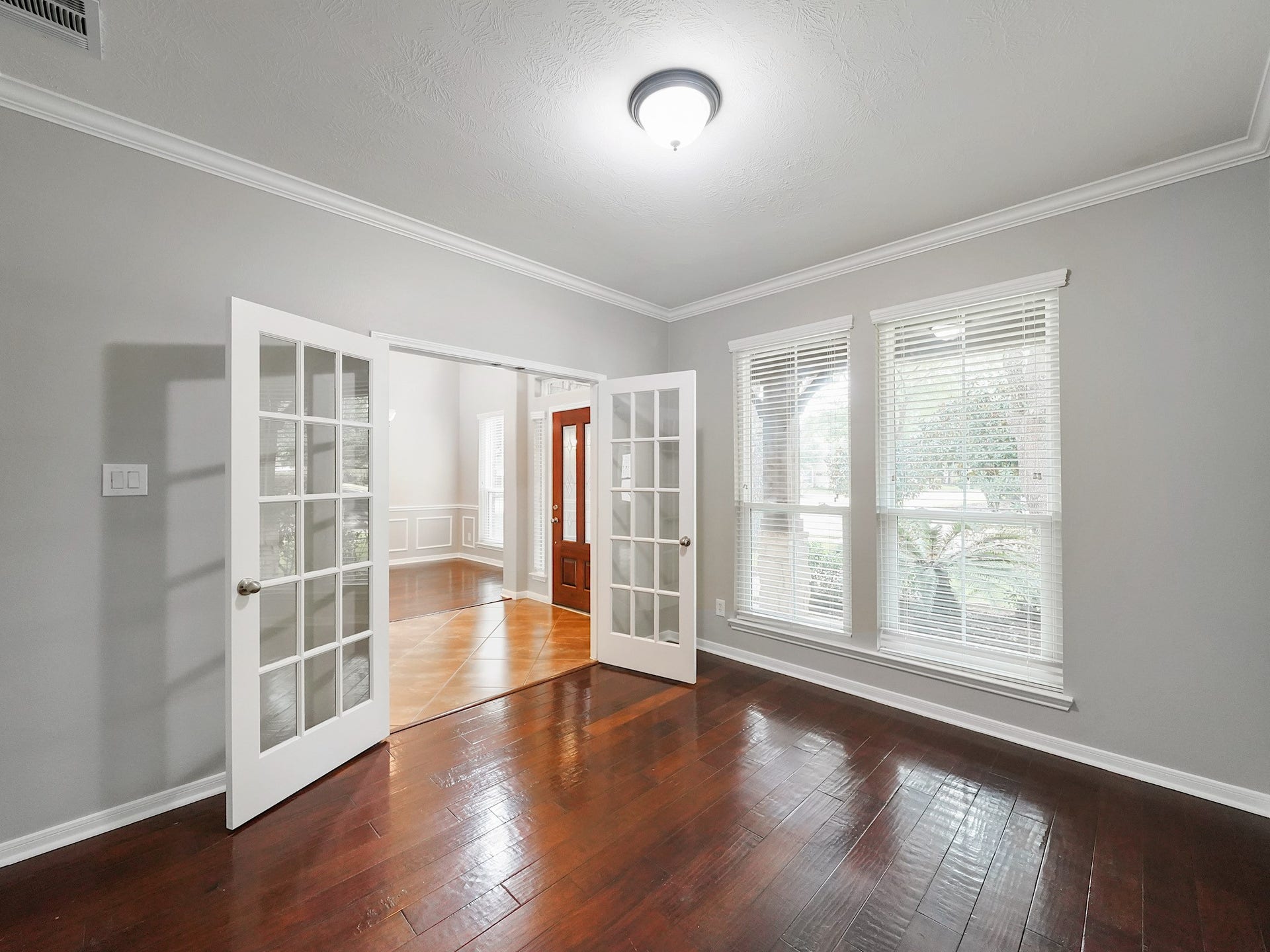 The dedicated study offers front-facing windows, crown molding, and flexible space behind French doors