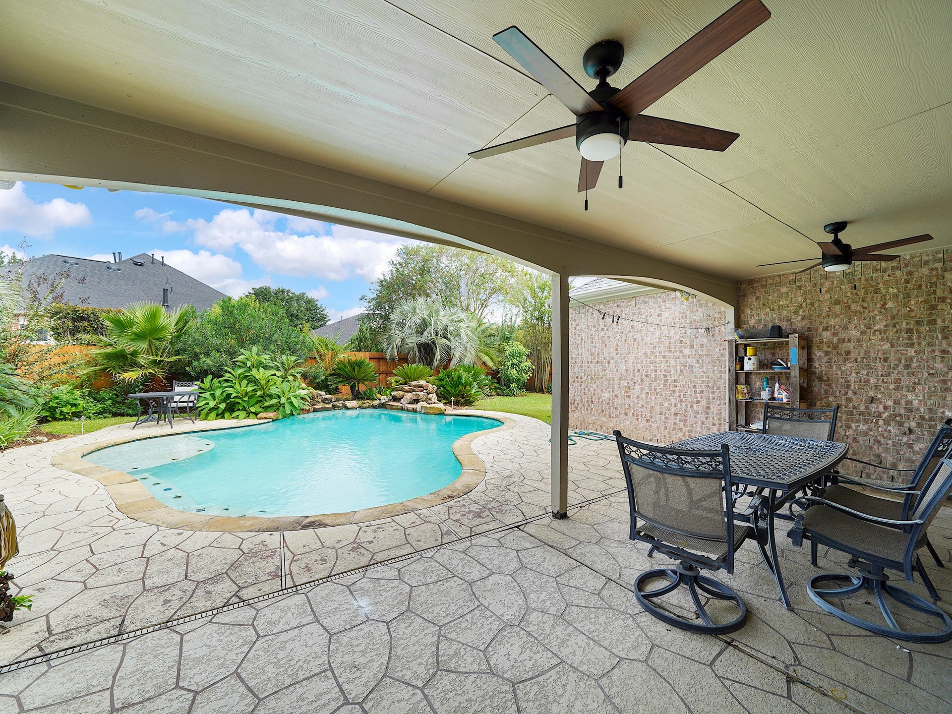 A sneak peek of the backyard oasis, where the covered patio and sparkling pool invite relaxed afternoons and easy entertaining.