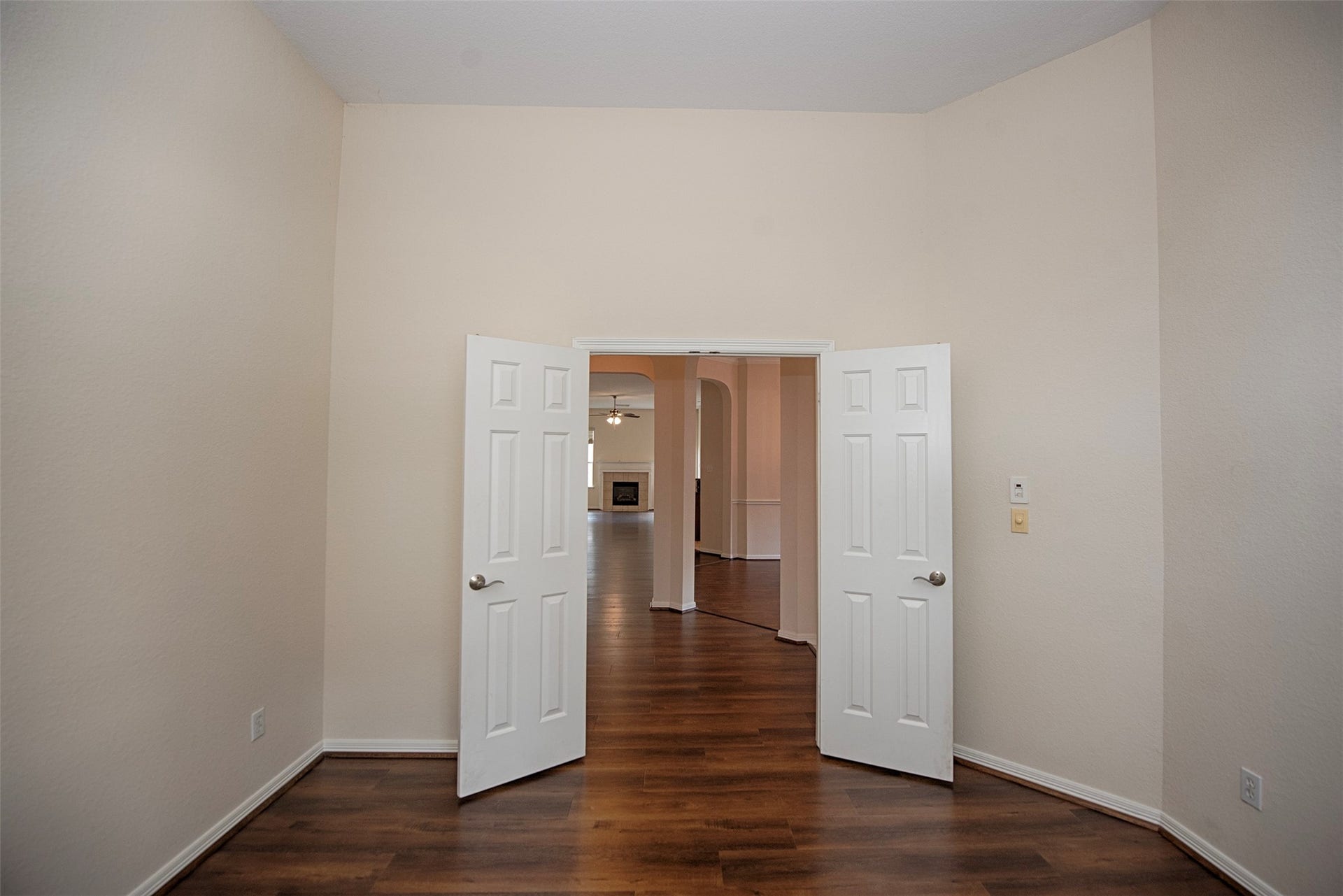 A view of the home office showing the gorgeous laminate wood floors, high ceiling and easy access to the rest of the home.  This room easily has enough room to install a closet and use it for a fourth bedroom.
