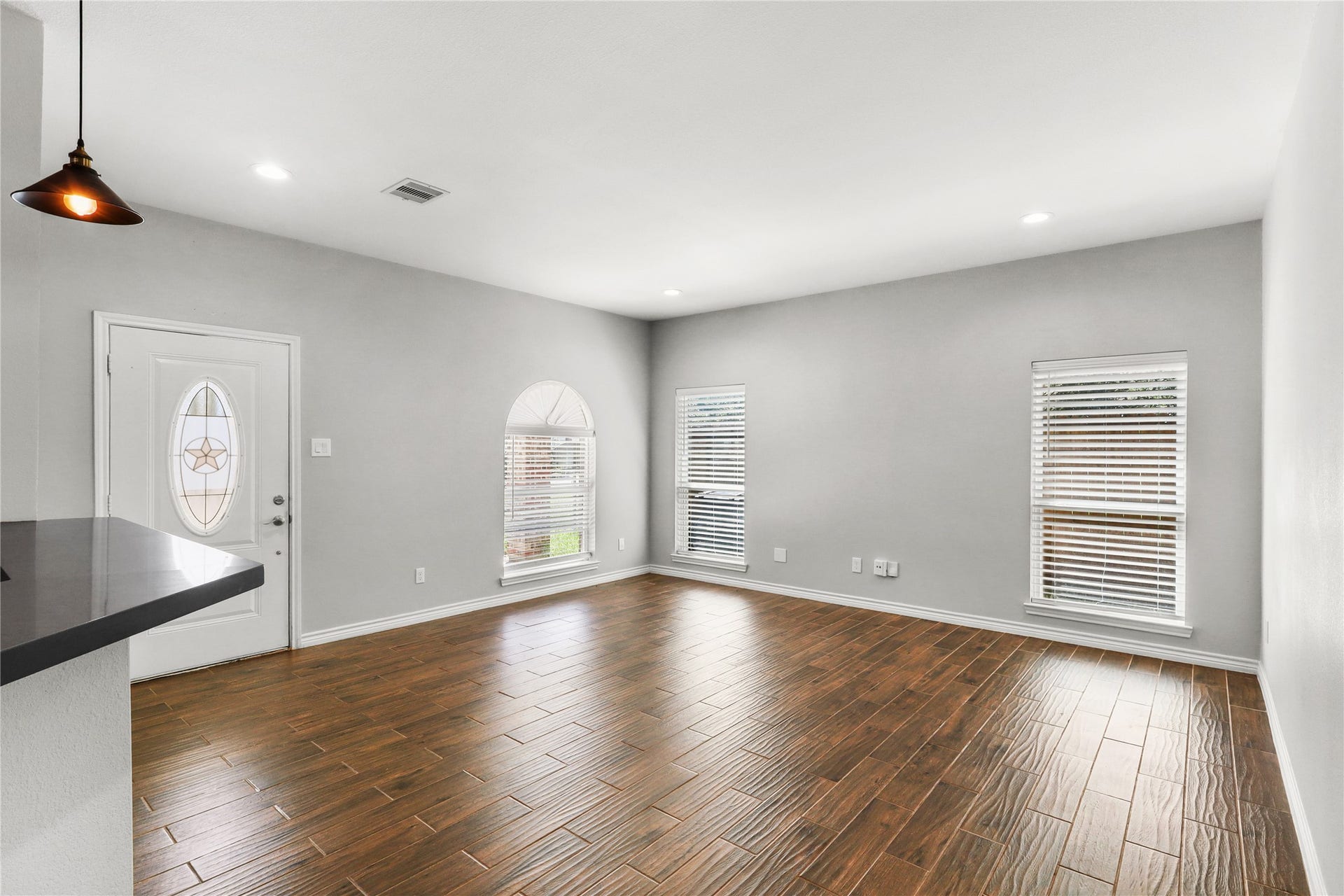 507 E Foley Street, Alvin, TX 77511 View of the living room and a front door. Look at all the windows. Two inch white blinds already added to every window.