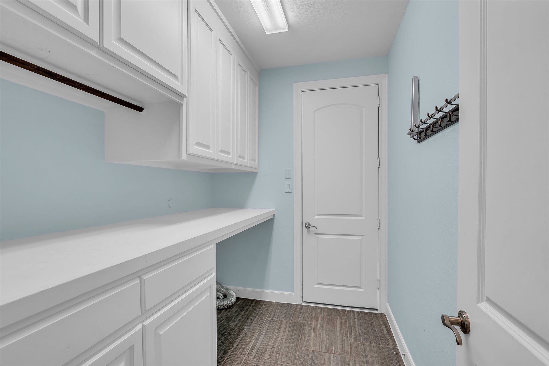 Laundry room has additional storage cabinets with counters