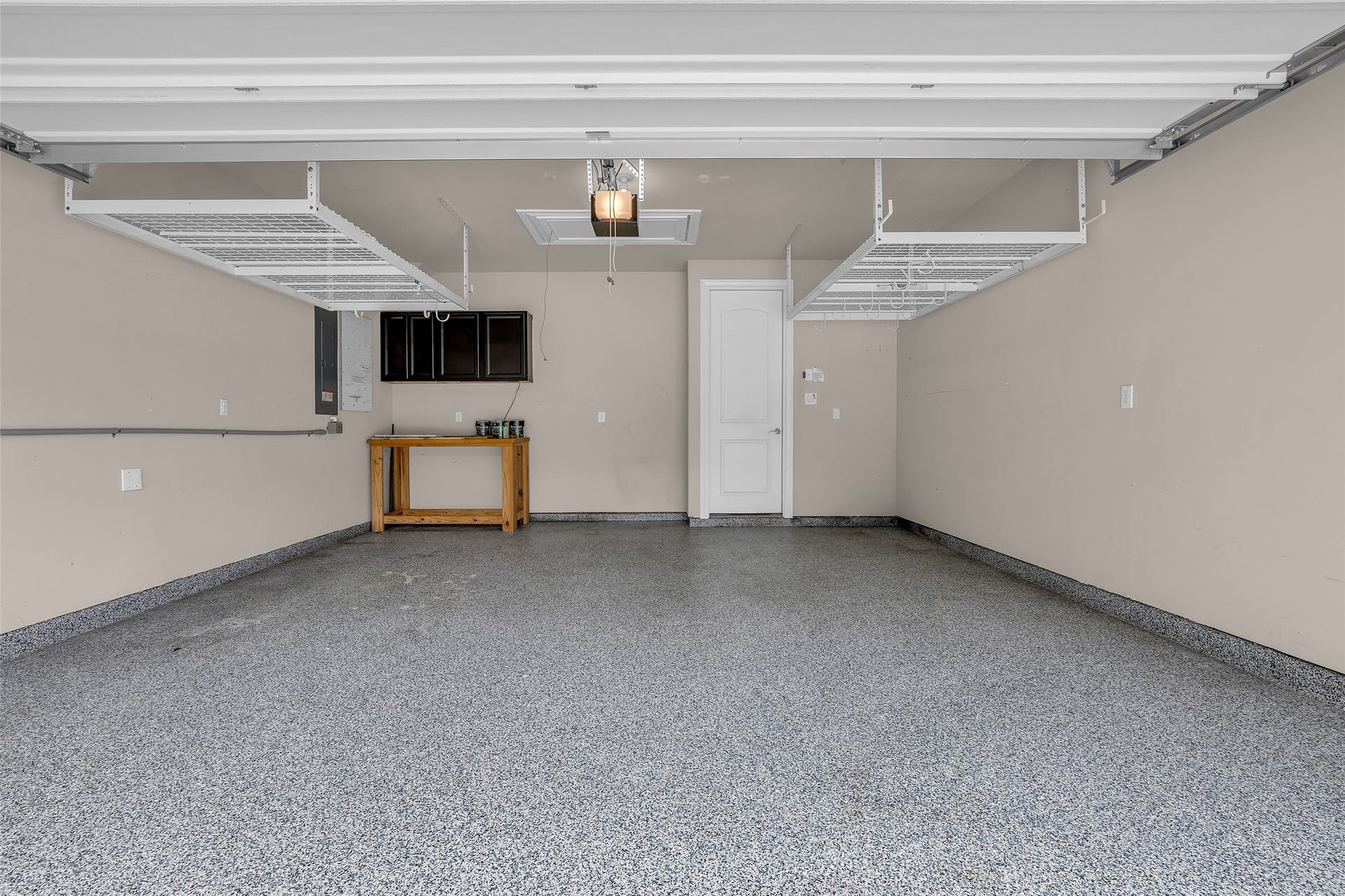 Garage includes epoxy flooring and overhead shelving