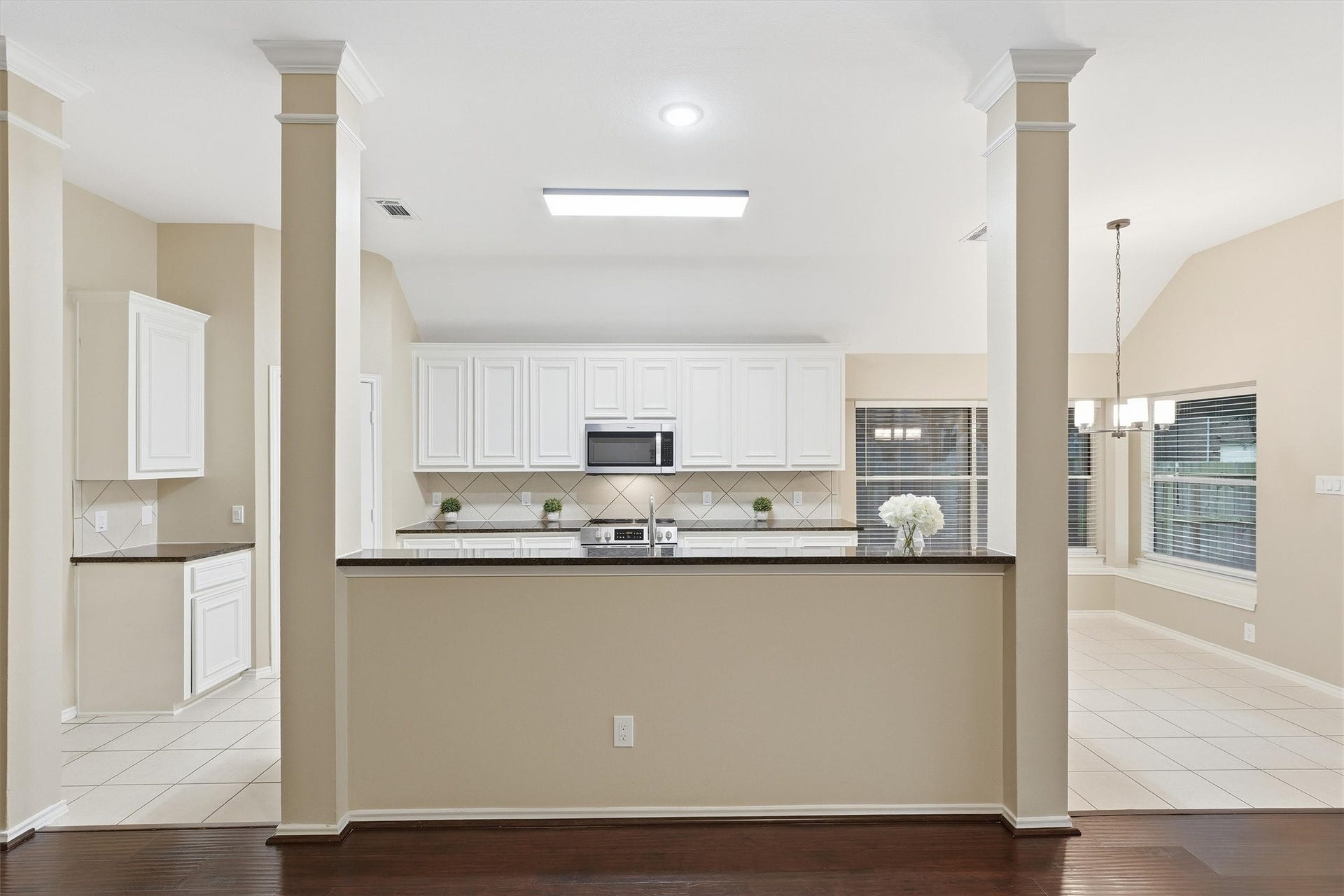View from the living room across the raised breakfast bar into the spacious kitchen and adjoining breakfast nook.