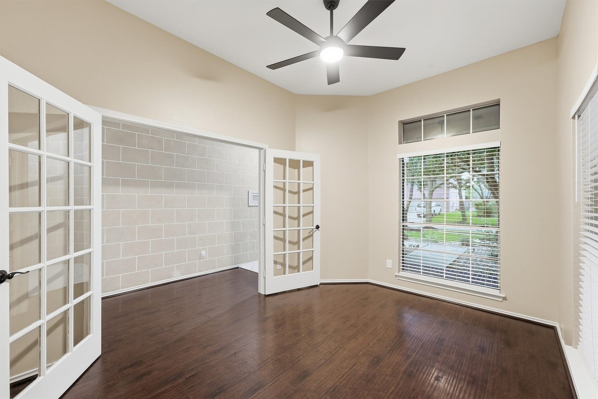 Flex space or study showing double French doors that open to the entryway, high ceilings, and ample natural light.