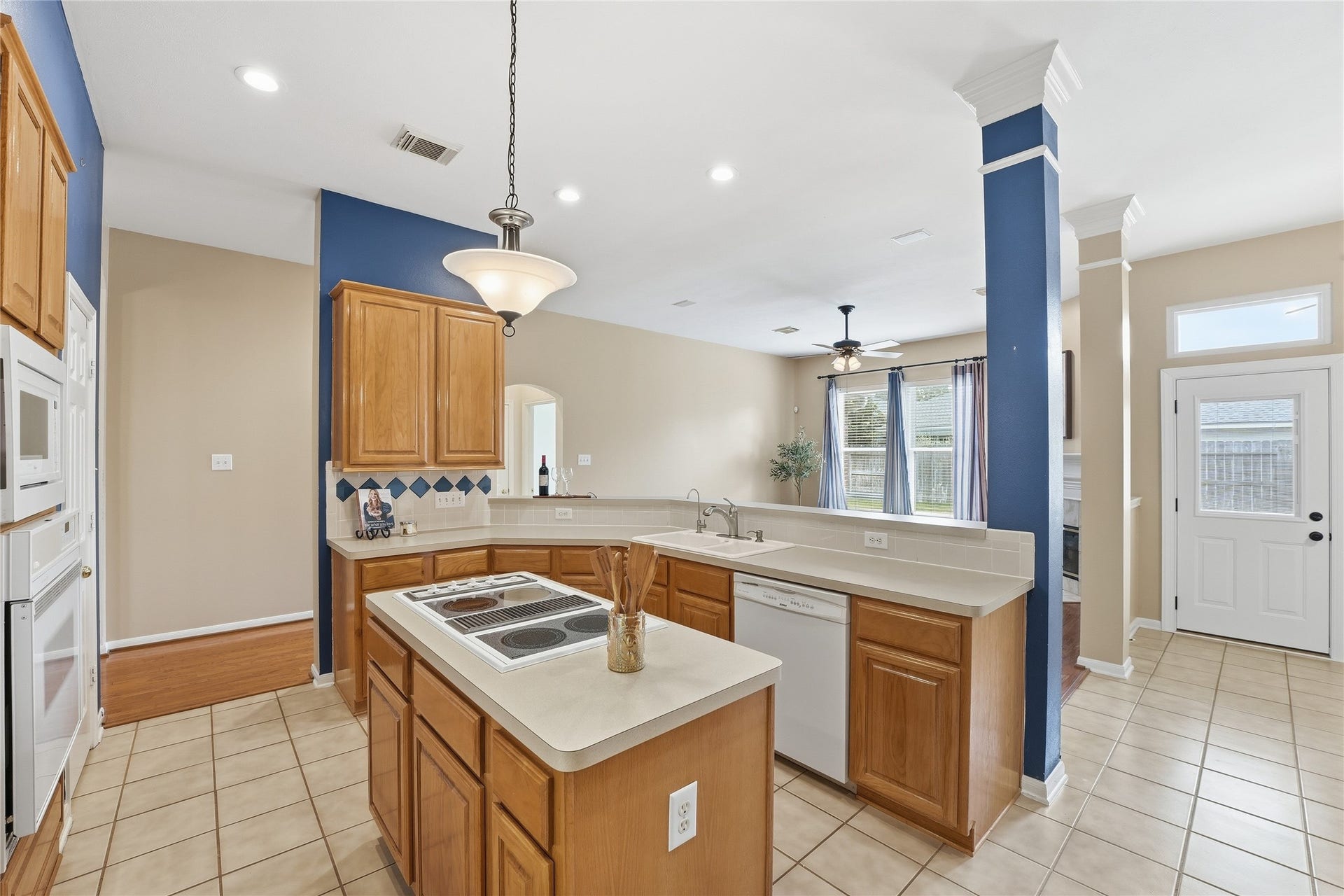 8027 Summer Brook Court, Sugar Land, TX 77479 Spacious kitchen with island cooktop, breakfast bar, and the kitchen sink overlooking the den.