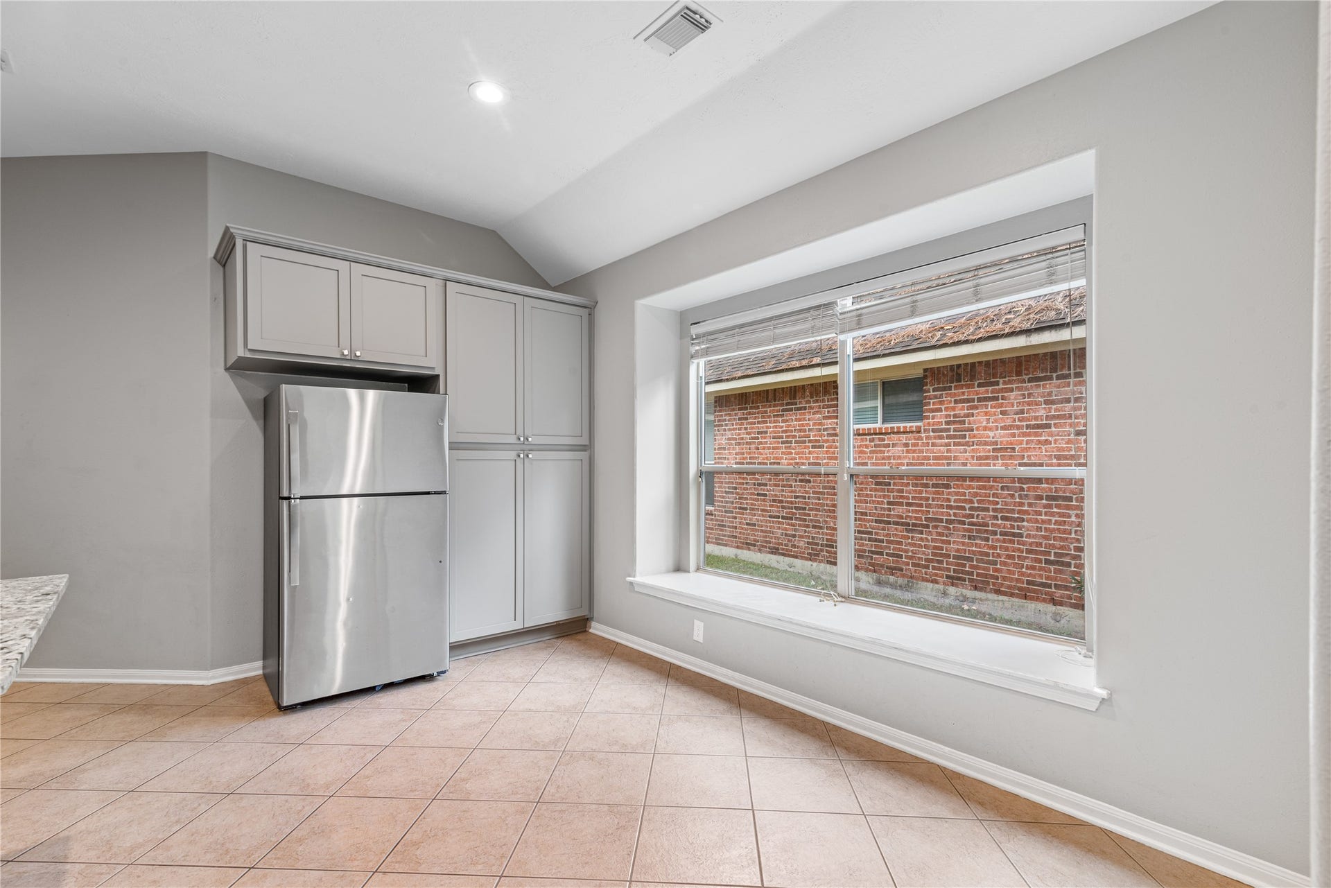 66 Bryce Branch Circle, Spring, TX 77382 Bright kitchen area featuring sleek stainless steel appliances, ample cabinetry, and a large window offering lots of natural light.