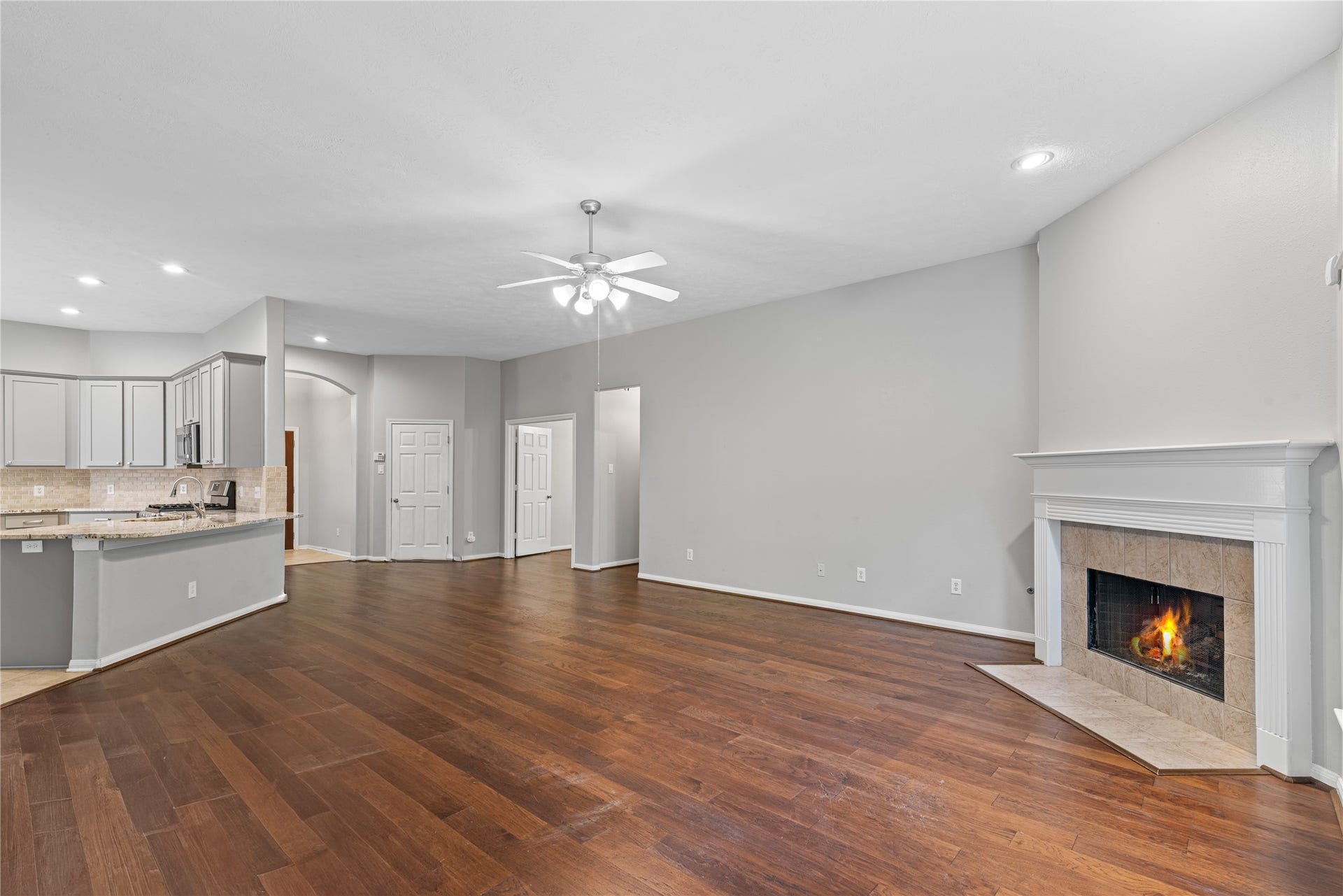 66 Bryce Branch Circle, Spring, TX 77382 Spacious open-concept living area featuring a cozy fireplace, and a modern kitchen with ample cabinetry and a breakfast bar.