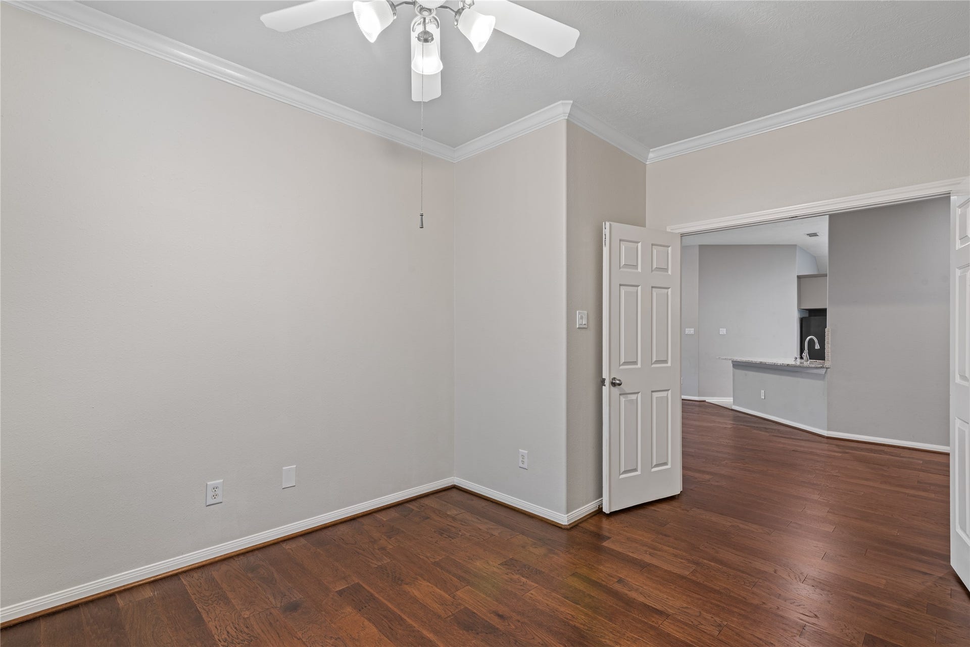 66 Bryce Branch Circle, Spring, TX 77382 Another view of home office with neutral walls, and a ceiling fan. An open doorway leads to the kitchen area, creating a seamless flow between spaces.