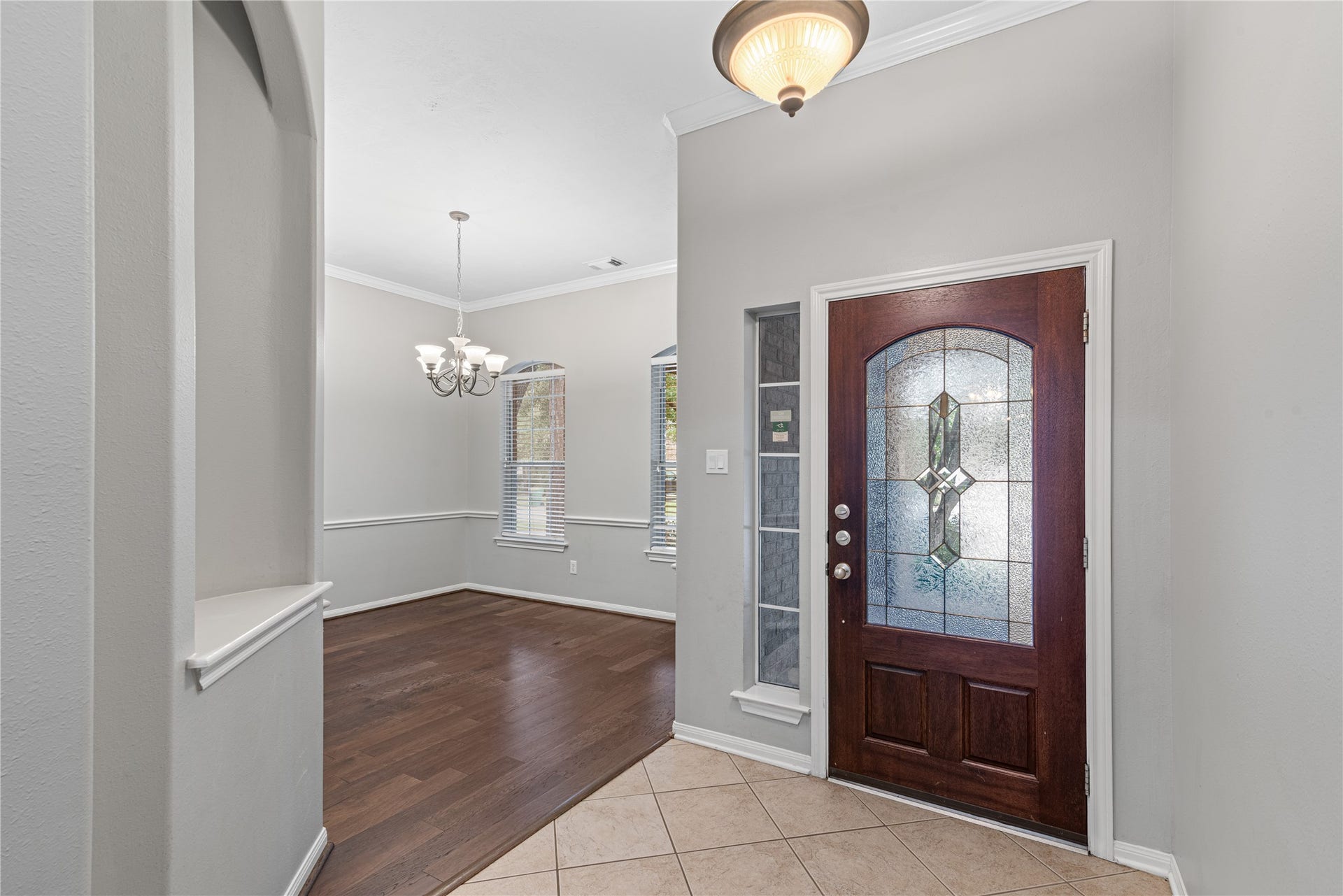 66 Bryce Branch Circle, Spring, TX 77382 Elegant entryway with a stylish glass-paneled door, leading into a bright formal dining room.