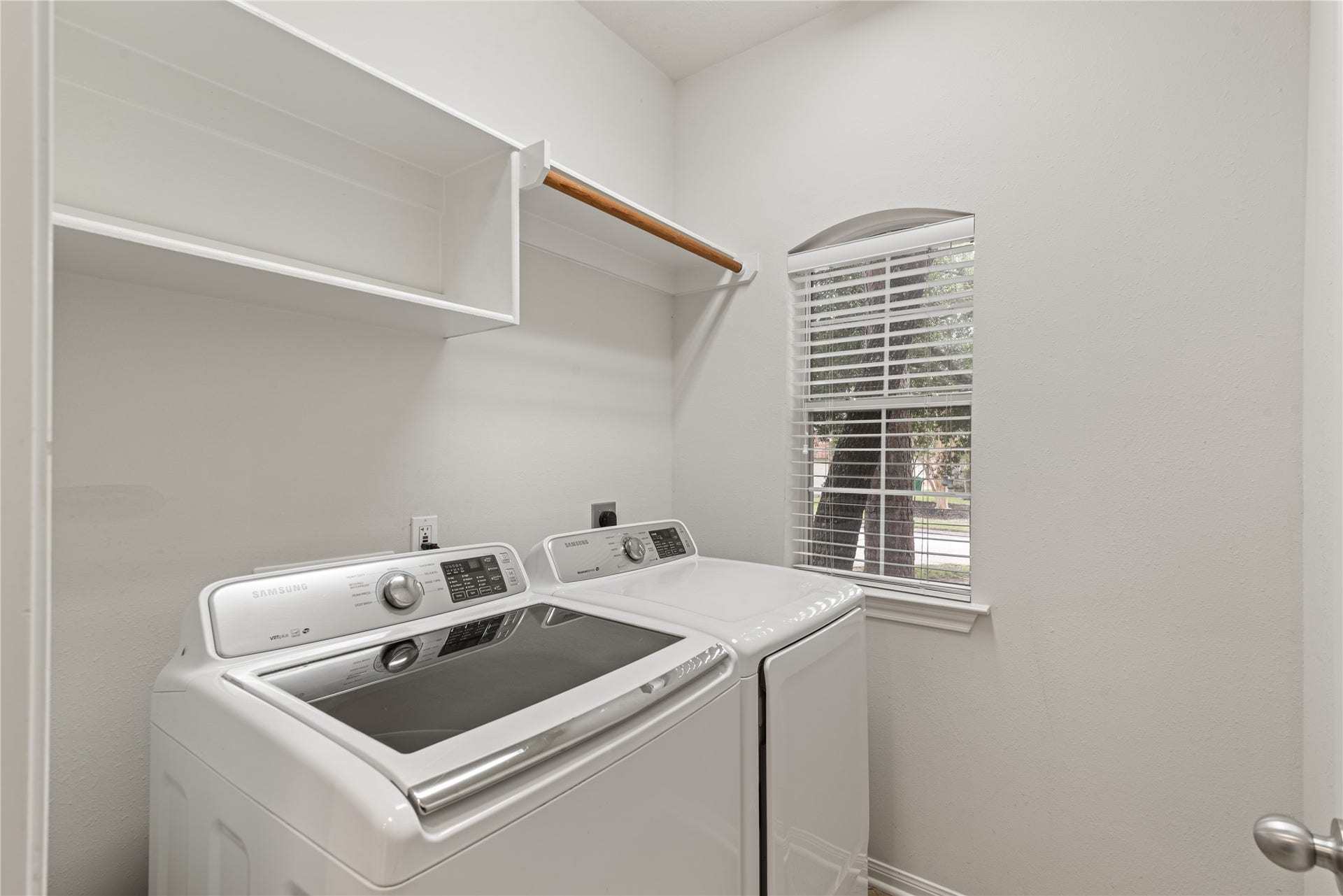 66 Bryce Branch Circle, Spring, TX 77382 Bright and functional laundry room located inside the home. It features modern appliances, ample shelving, and a large window for natural light.