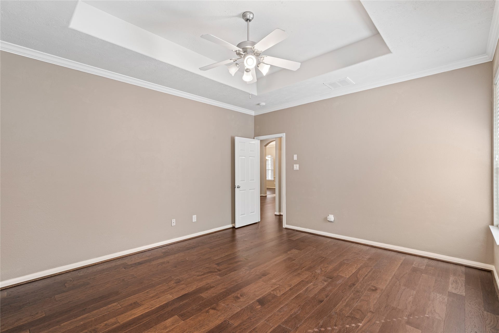 66 Bryce Branch Circle, Spring, TX 77382 Spacious master bedroom featuring neutral walls and a stylish tray ceiling with a ceiling fan for added comfort.