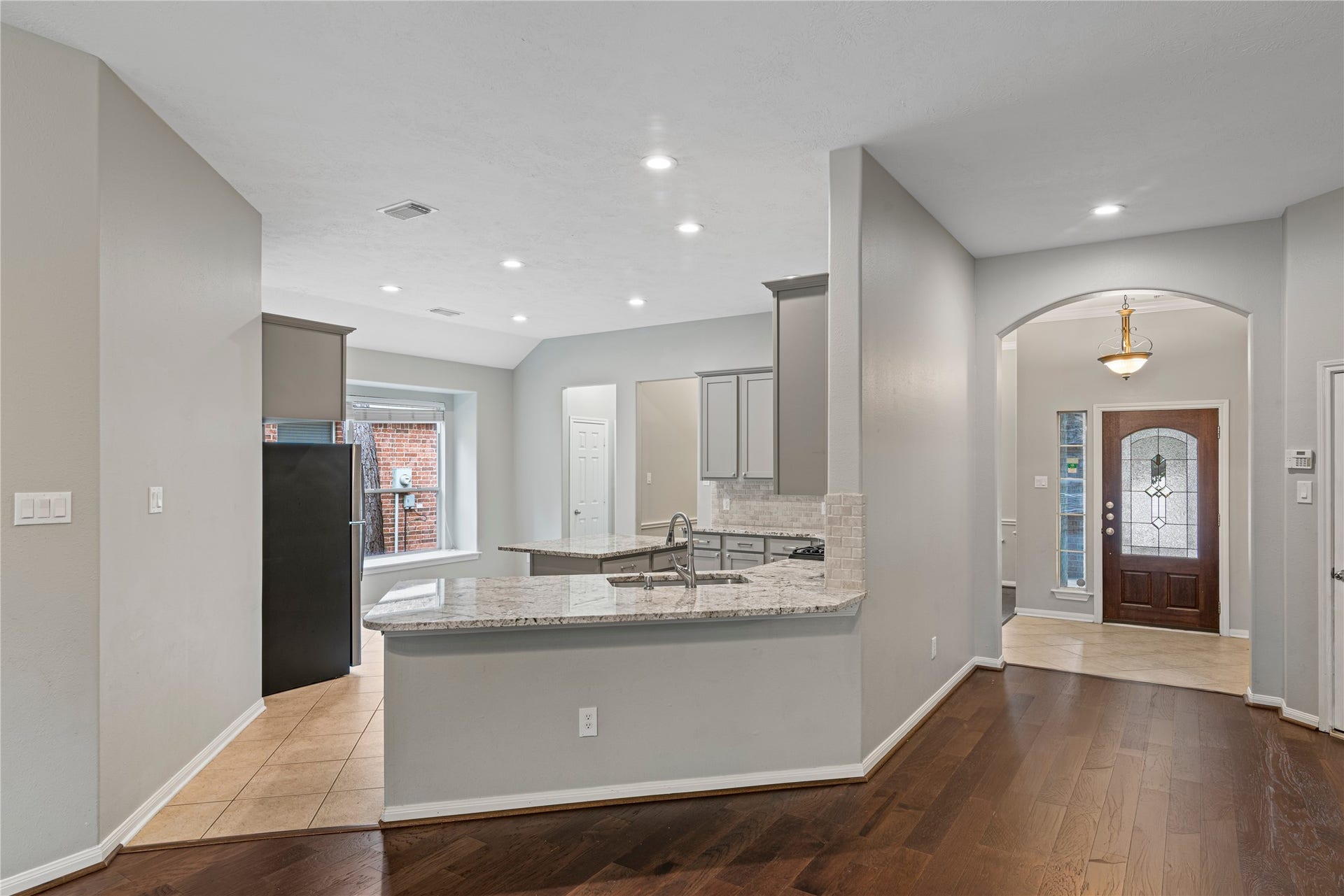 66 Bryce Branch Circle, Spring, TX 77382 Modern kitchen with granite countertops and stainless steel appliances flows into an inviting entryway.