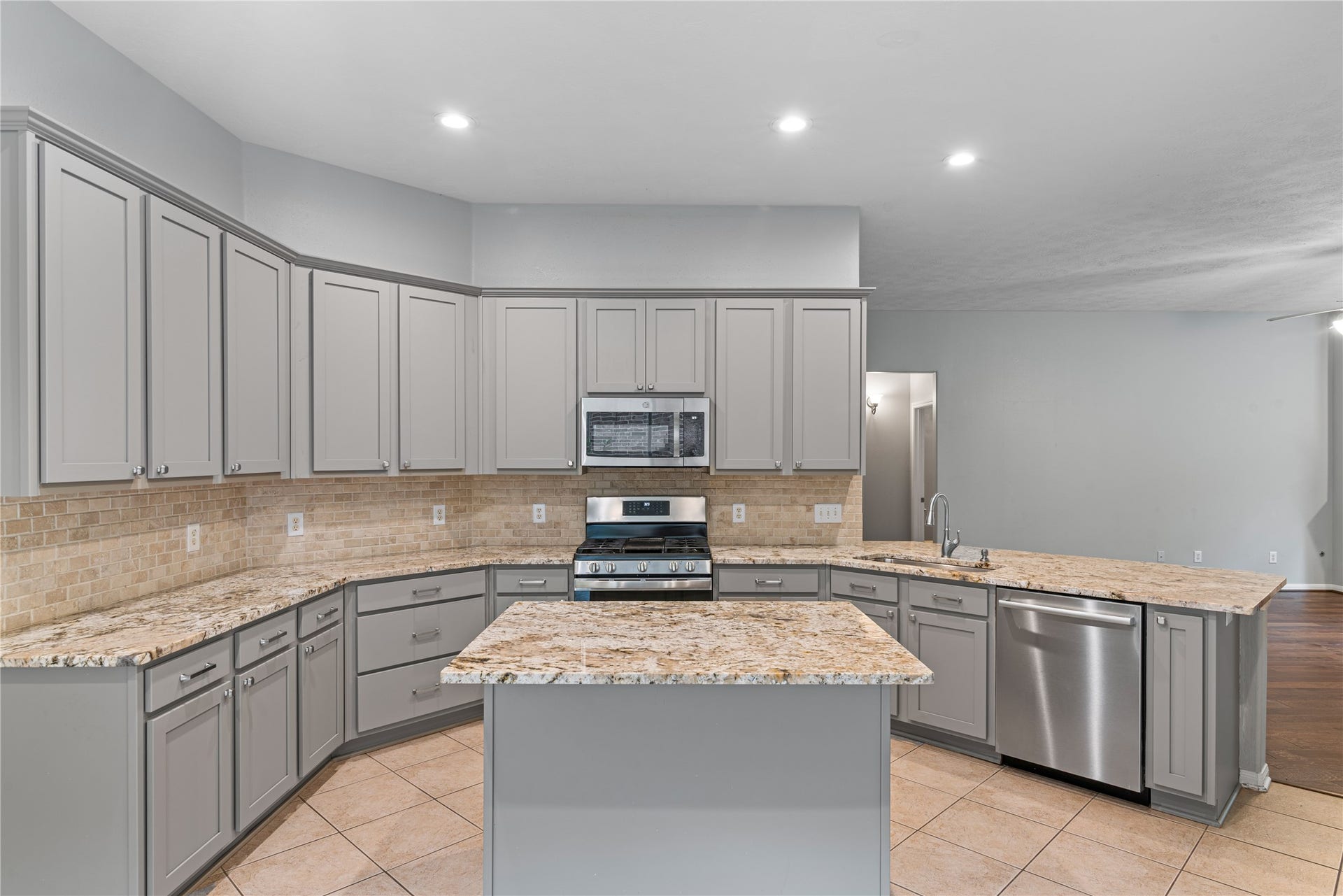 66 Bryce Branch Circle, Spring, TX 77382 Spacious kitchen with modern stainless steel appliances, ample cabinetry, and elegant granite countertops, perfect for culinary enthusiasts.