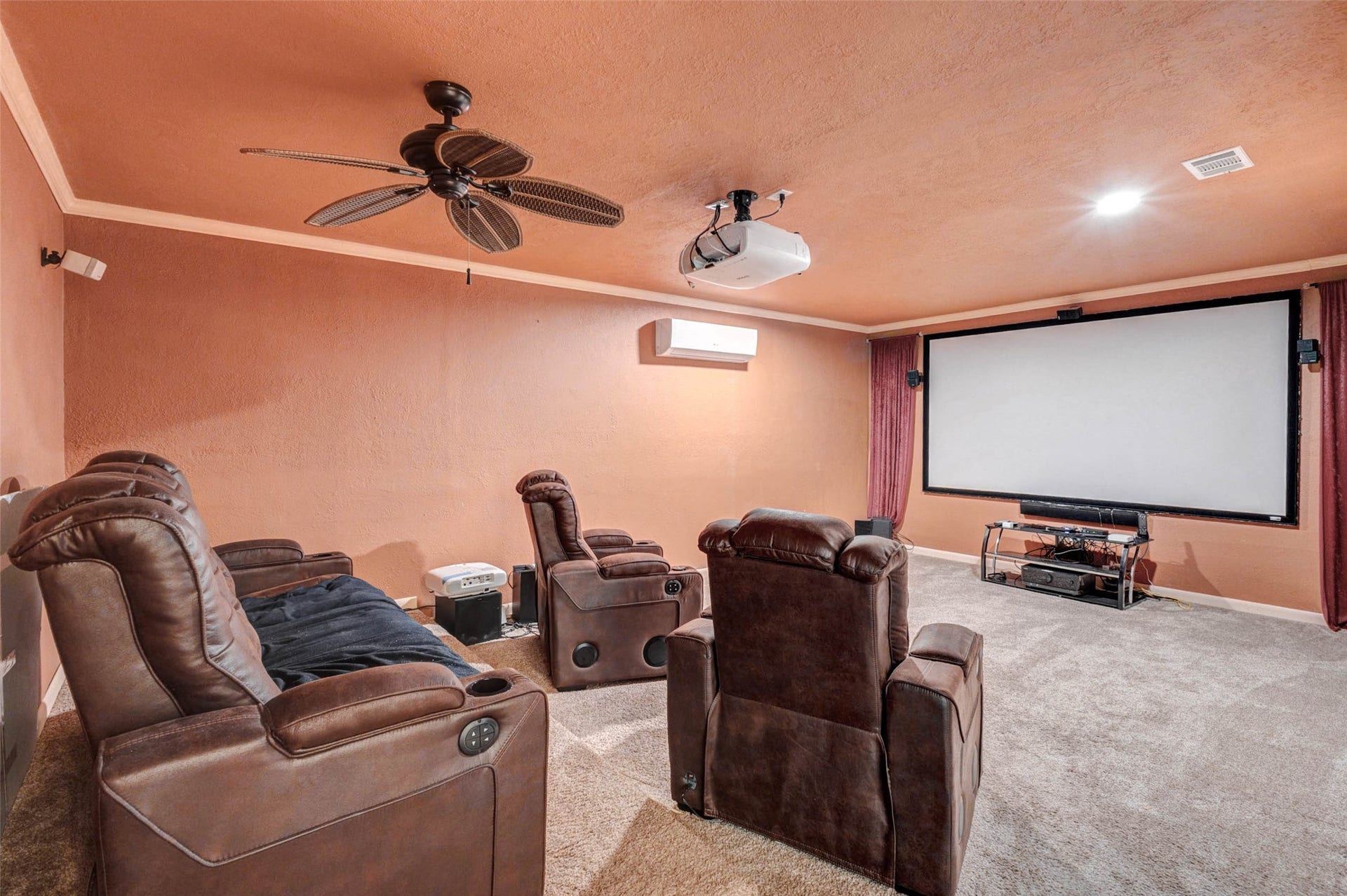 11418 Cedarwood Drive, Humble, TX 77338 A dedicated media room creates the perfect spot for movie nights, game days, and relaxed entertaining. With plush carpet, theater-style seating, a large projection screen, projector, ceiling fan, and warm wall tones, this space is designed for comfort and an immersive viewing experience away from the main living areas.