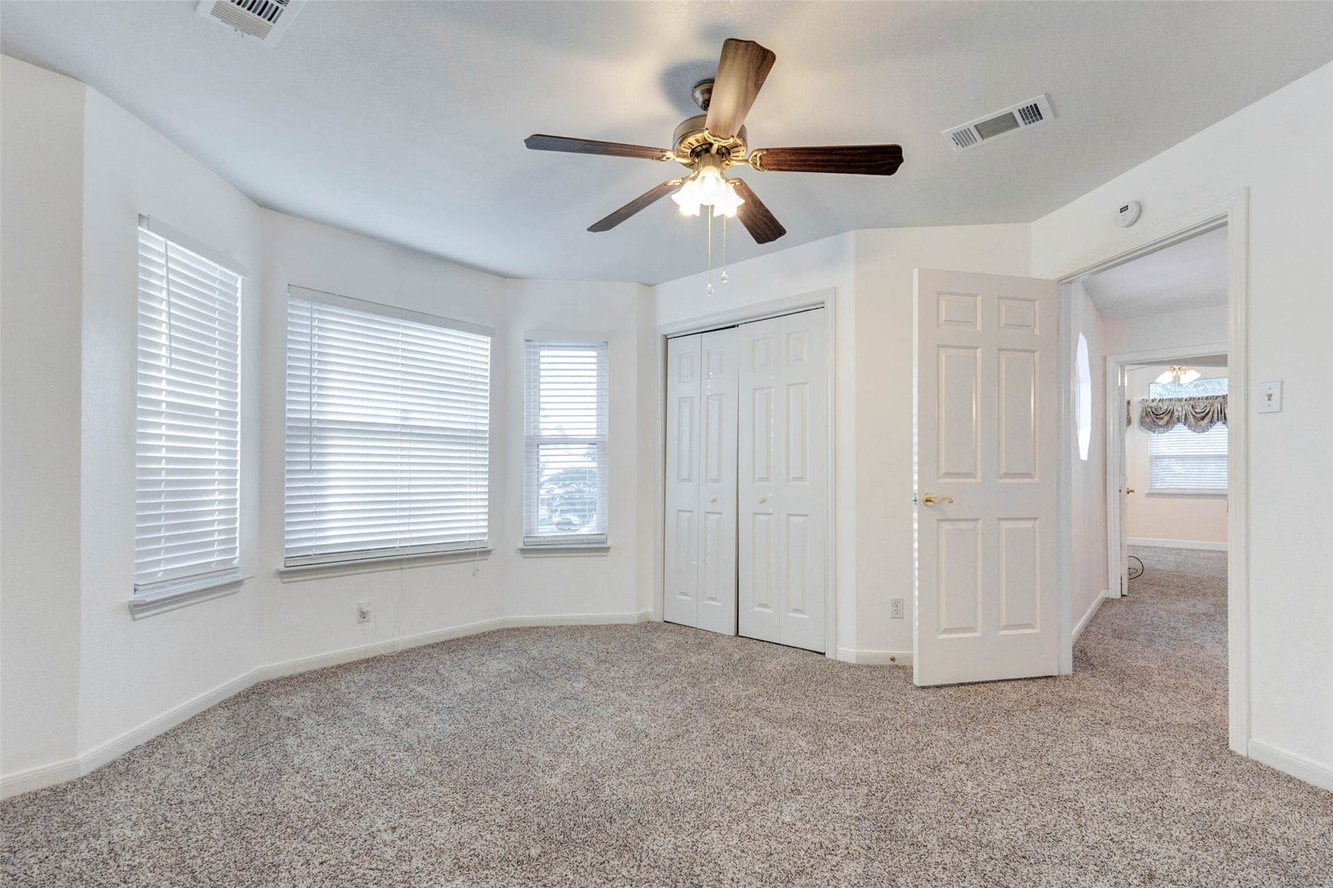 11418 Cedarwood Drive, Humble, TX 77338 This secondary bedroom offers soft carpet, multiple windows with blinds, a ceiling fan, closet storage, and neutral walls ready for personal style. The room provides comfortable flexibility for a guest bedroom, childs room, home office, hobby space, or quiet retreat with easy access to the upstairs hallway.
